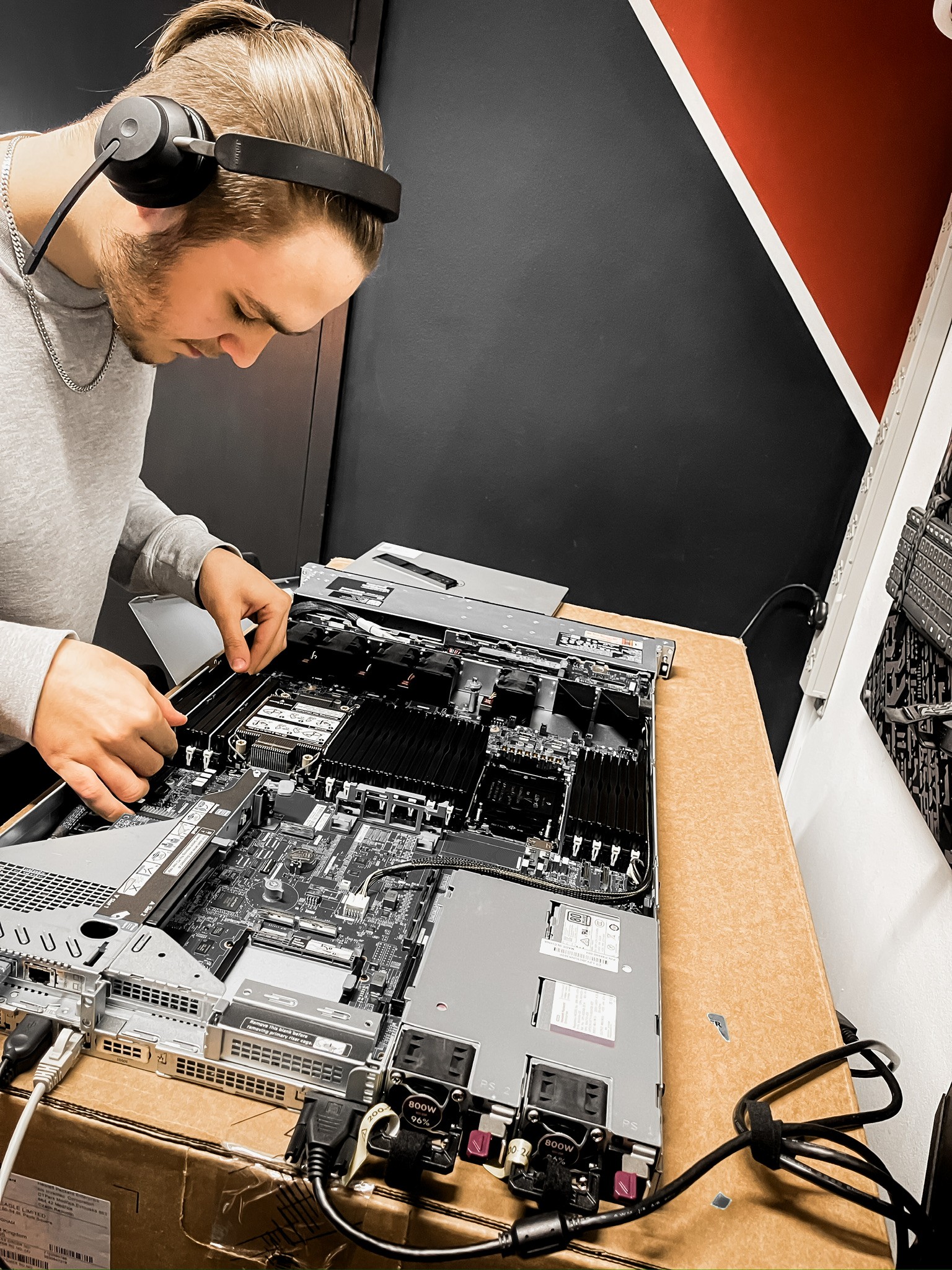 Person in dark clothing standing in moody, atmospheric lighting
