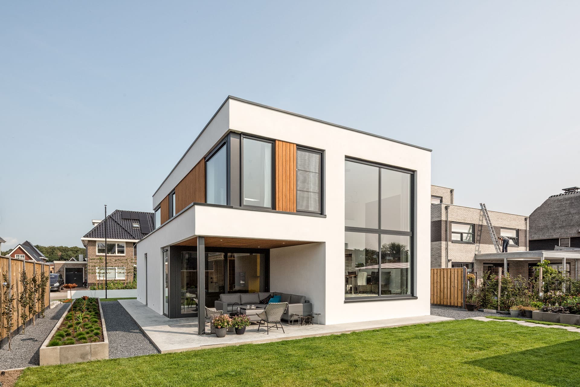 Modern villa in Apeldoorn met wit stucwerk, houten gevelbekleding en grote raampartijen aan de tuinzijde