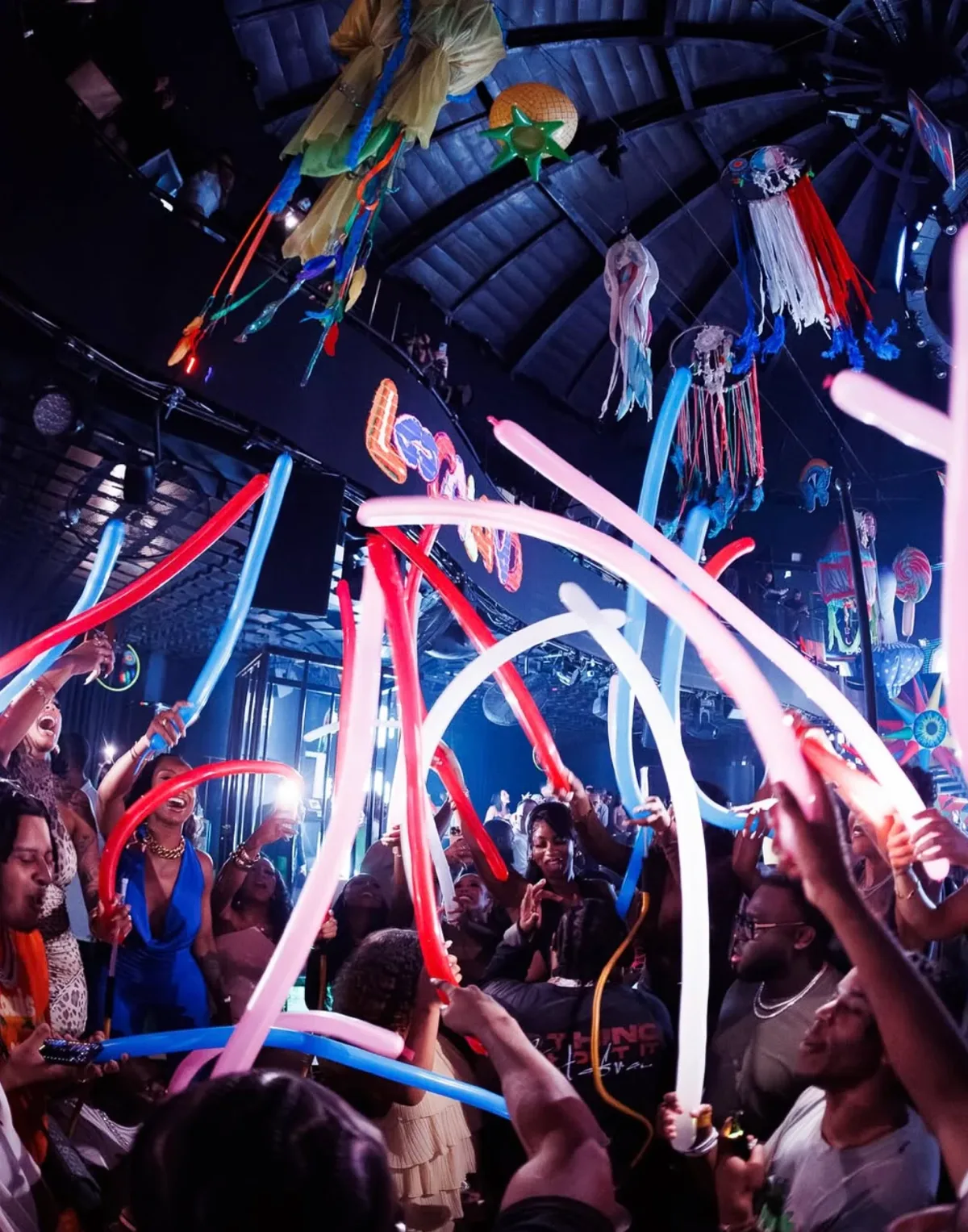 Crowd waving long red, white and blue balloons under the domed ceiling at BLU Dubai
