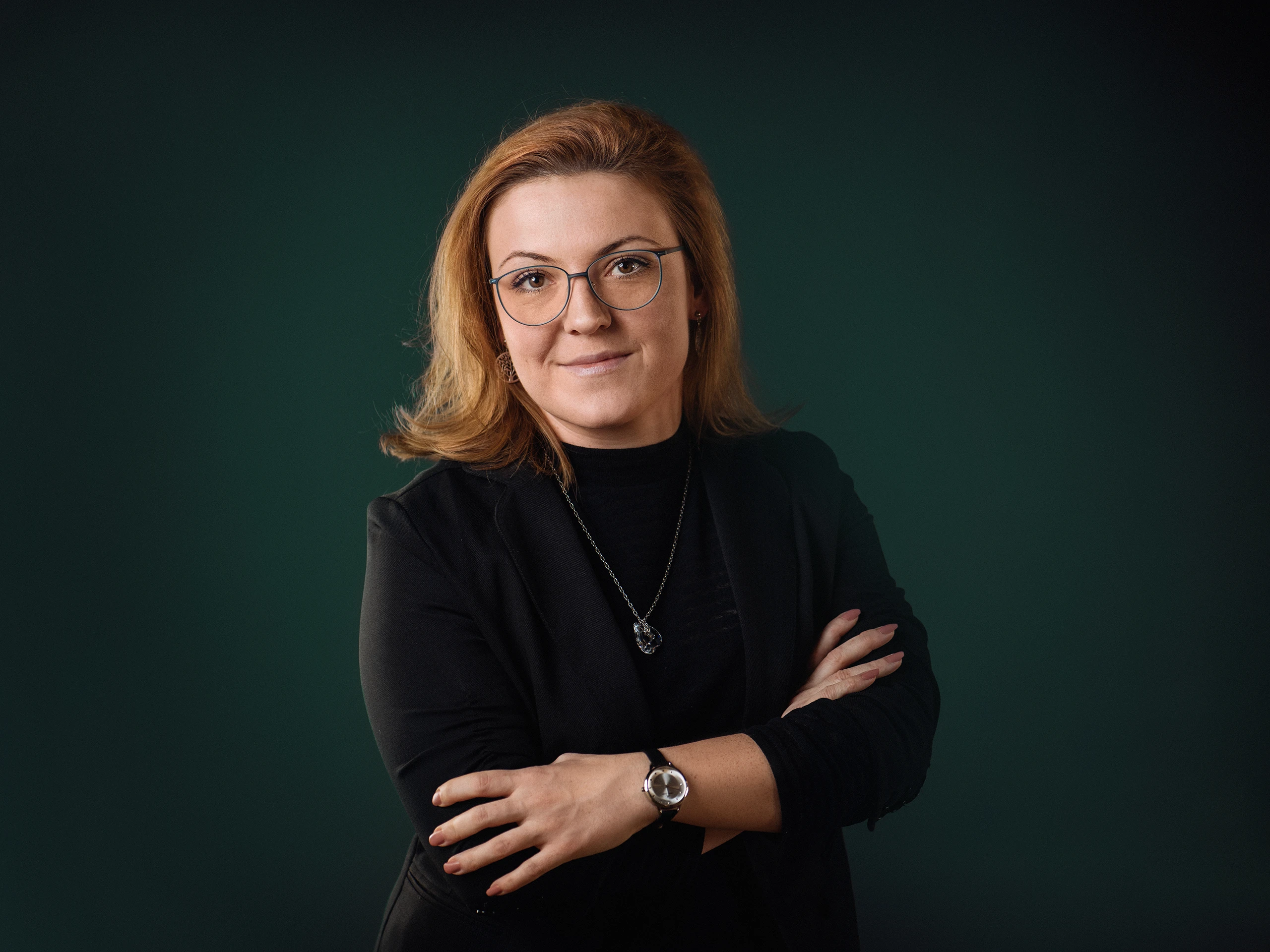 Devojka sa narandžastom kosom pozira za portret ispred zelene pozadine