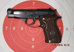 Beretta 87 pistola semiautomatica compatta calibro .22 LR con carrello in acciaio brunito e impugnatura in legno, fotografata su sfondo neutro