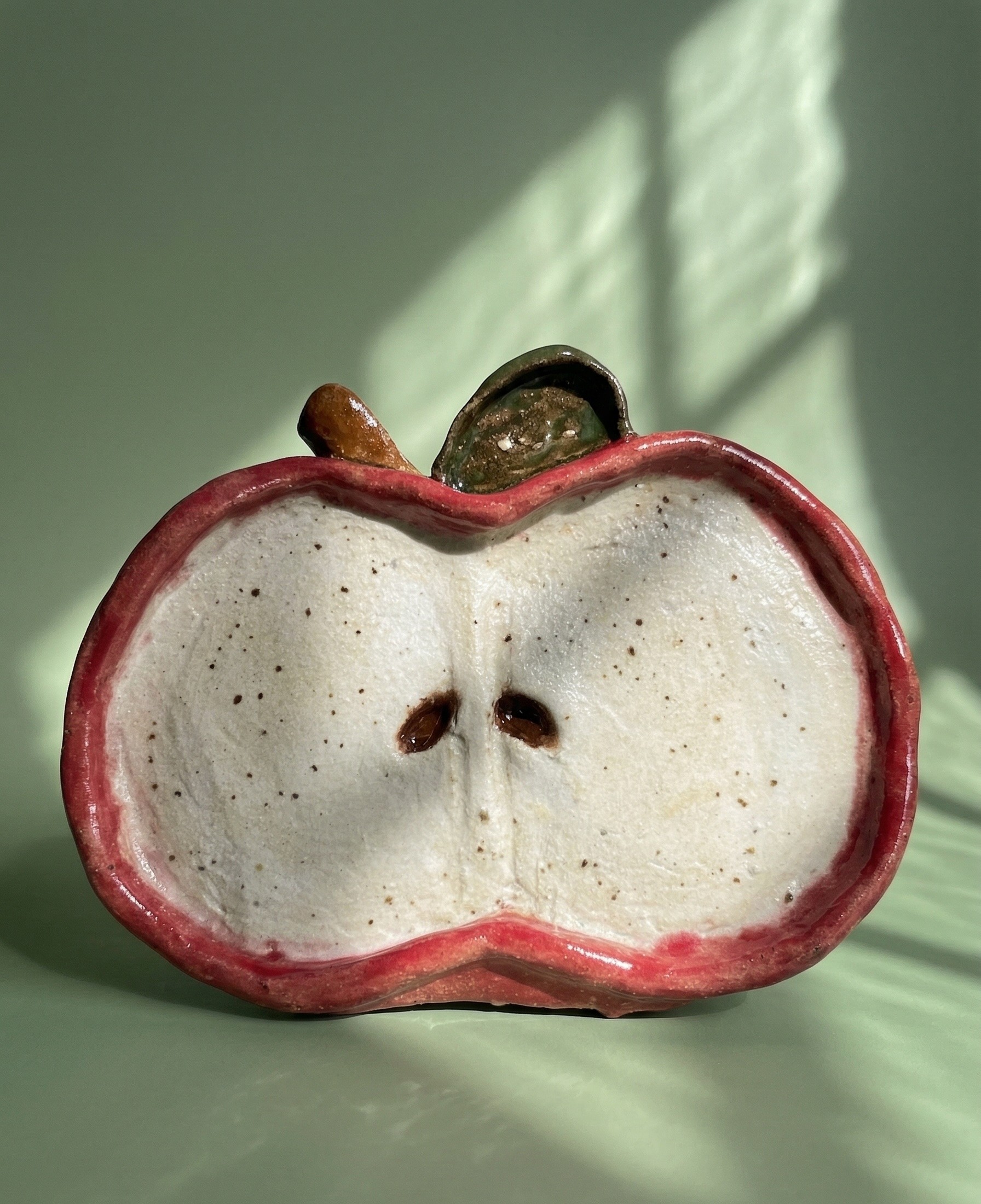 a ceramic plate shaped like an apple