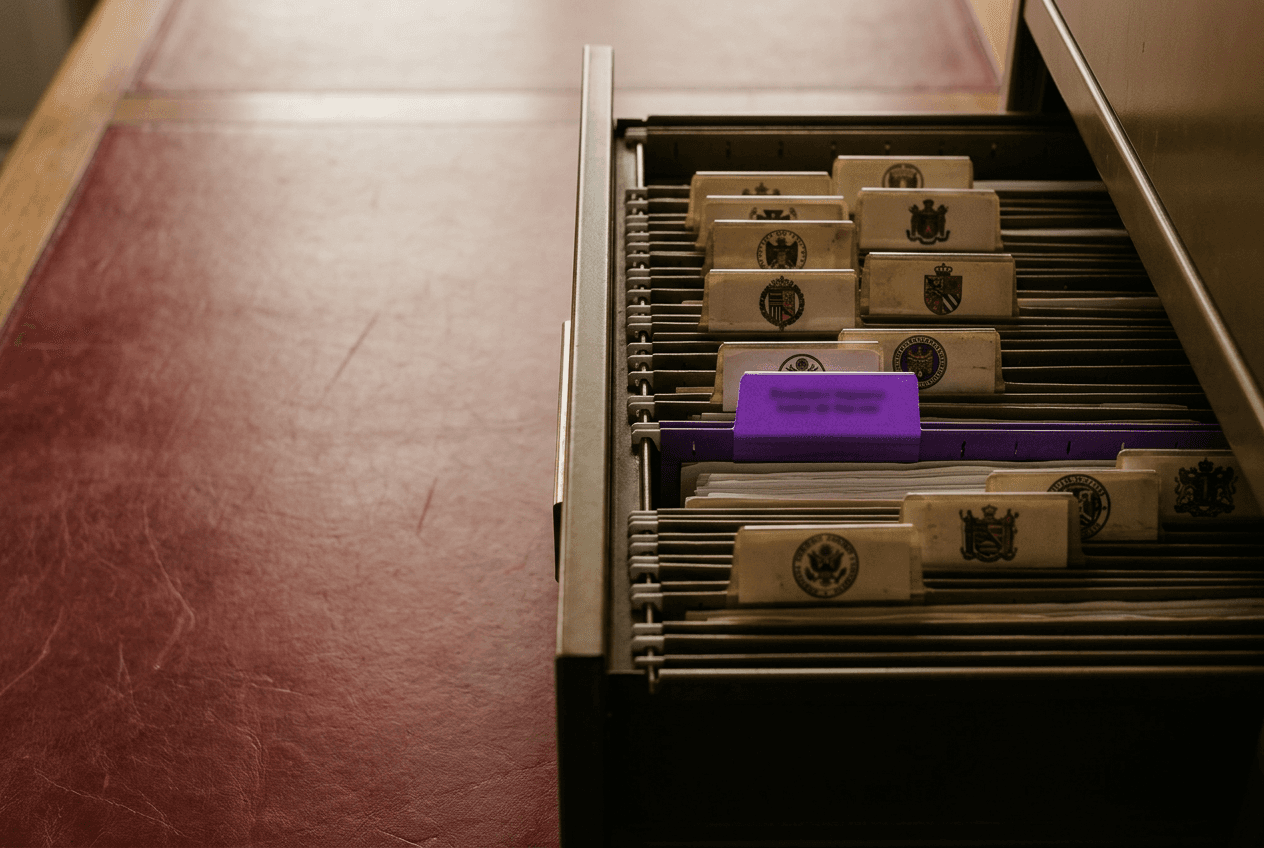 Ein aufgeklappter Aktenschrank voller Hängeregister mit Siegeln, ein Register ist herausgezogen.