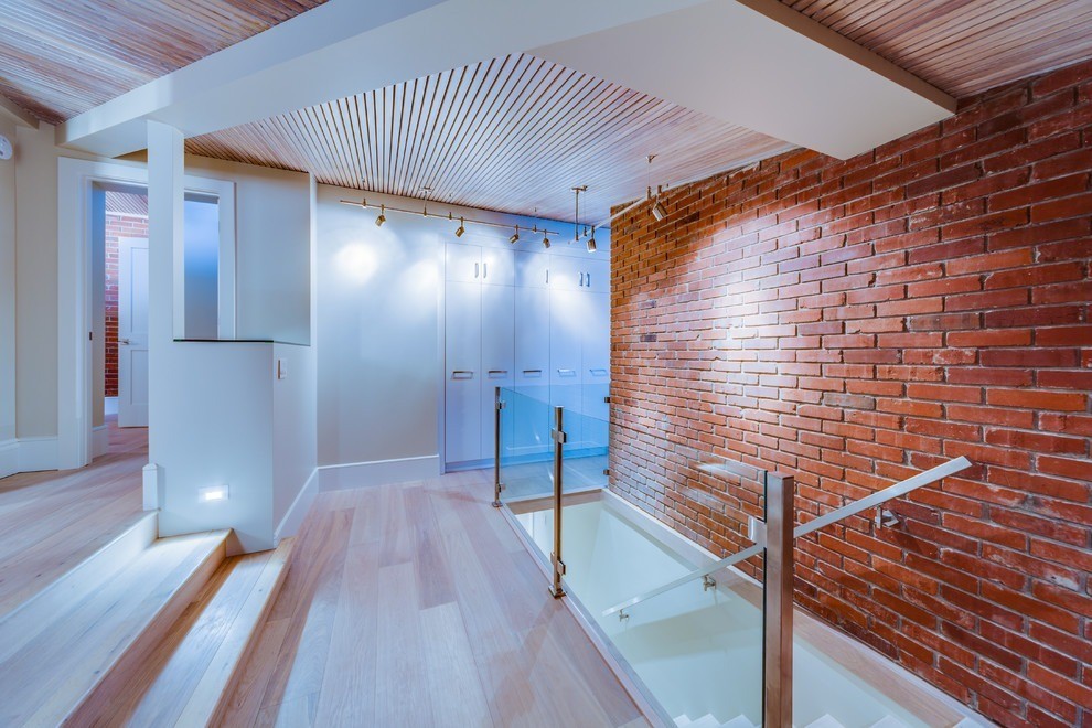 Image of Staircase with glass railing and brick wall in modern home design by KHD Homes builder.
