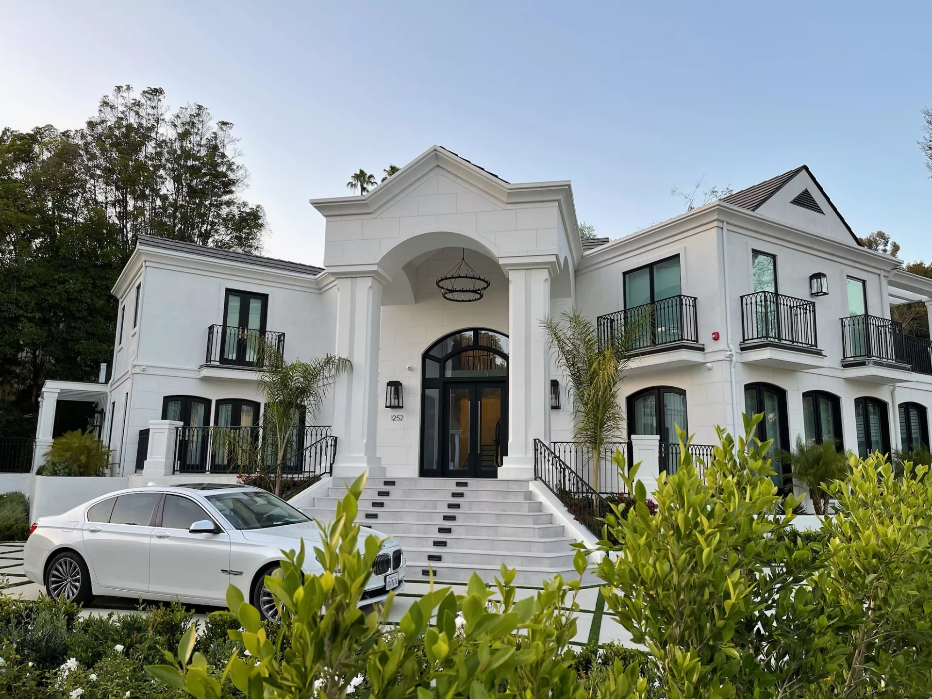 Two people sit across a table in a stylish room with red velvet walls and a large red pendant light. The mood is intimate and modern.