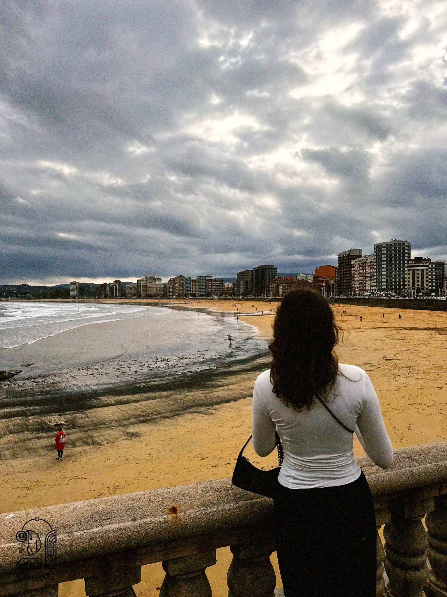 Une personne posant devant la plage de Gijon