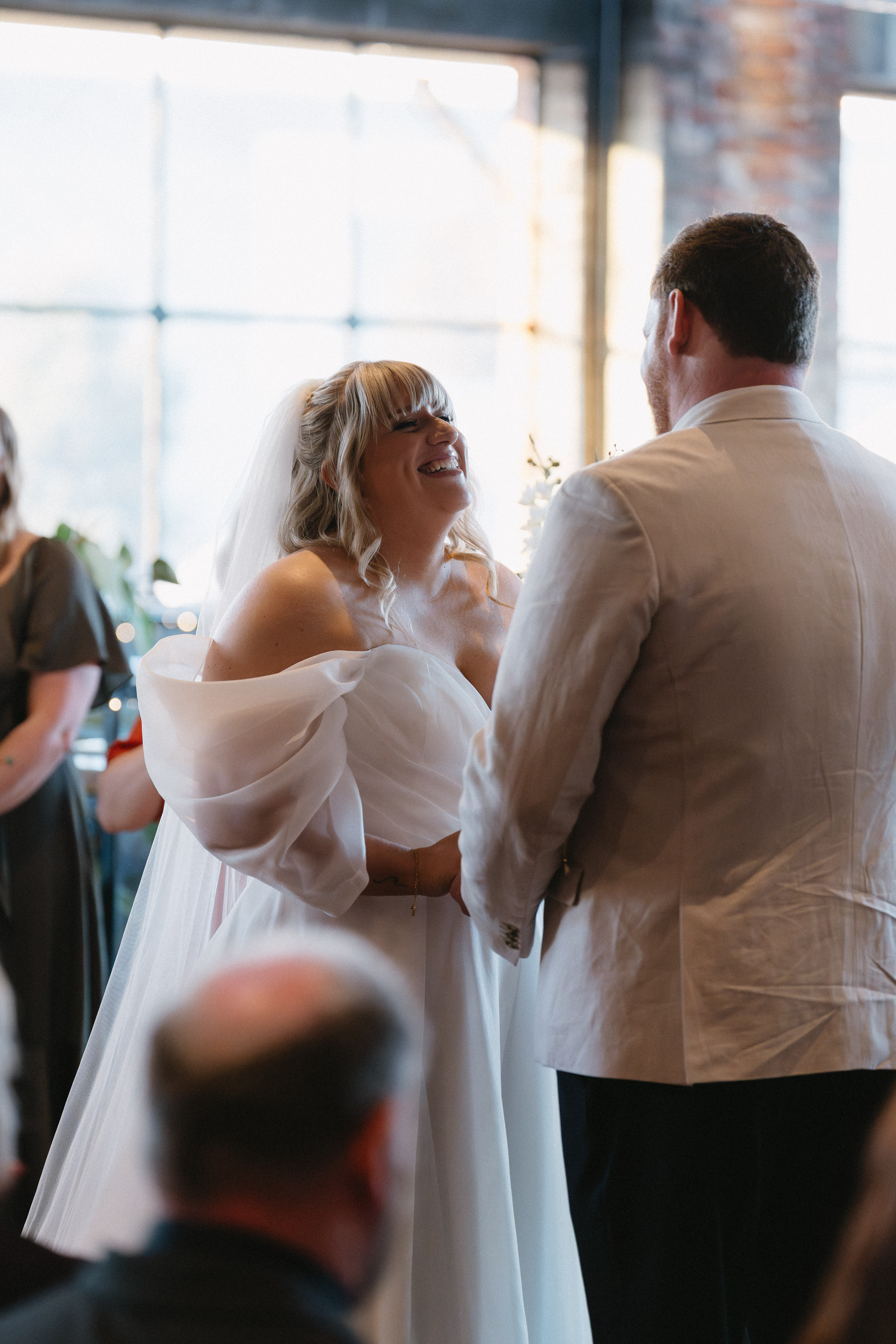 greyscale photo of man singing while holding guitar