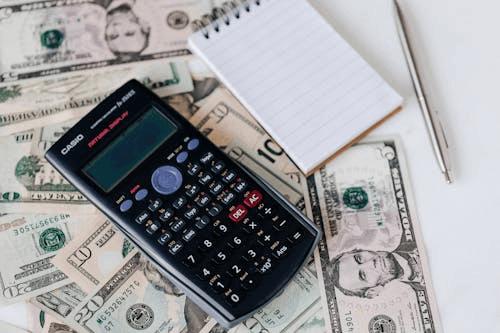 Calculator, cash, and notebook illustrating the average cost of filing bankruptcy in 2026