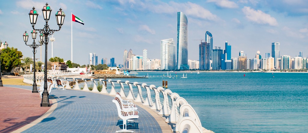 A view of the city skyline from a walkway in Al Forsan Village, showcasing modern buildings against a clear sky.