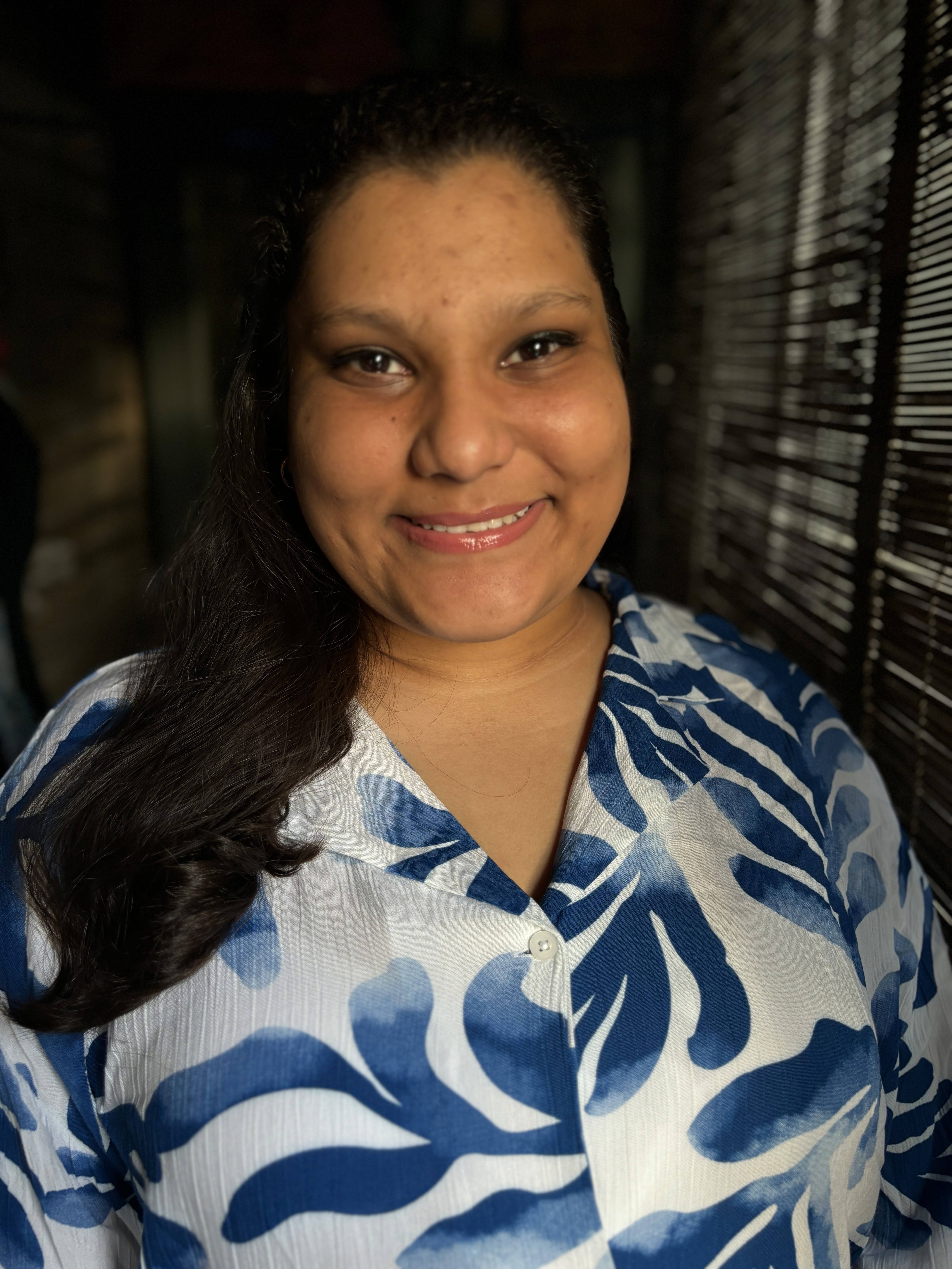 A thoughtful young person with dark hair gazes to the side, captured in soft black and white lighting.