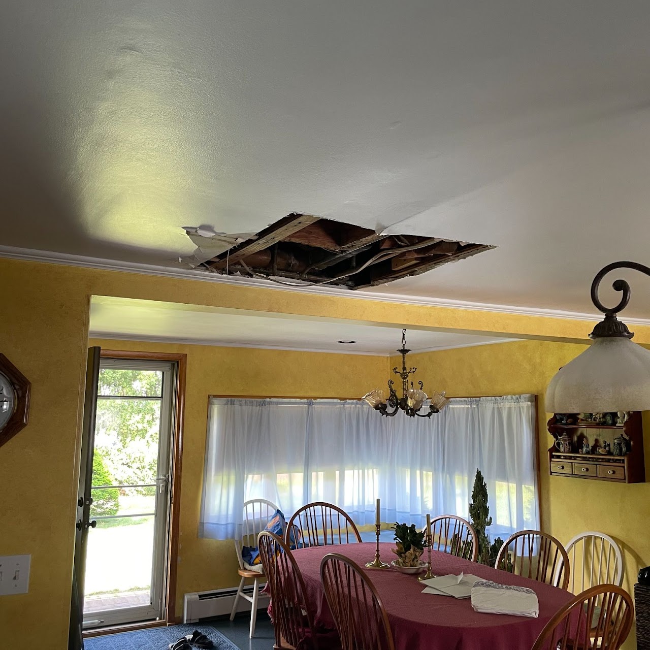 Collapsed water-damaged ceiling hole above dining room table