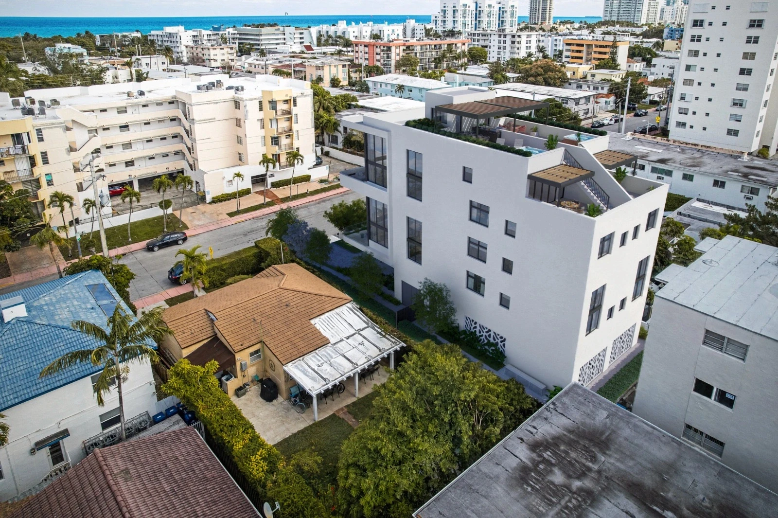 Aerial rear view of Byron Avenue Residence in North Beach, Miami Beach, with rooftop pergolas, plunge pools and ocean views beyond