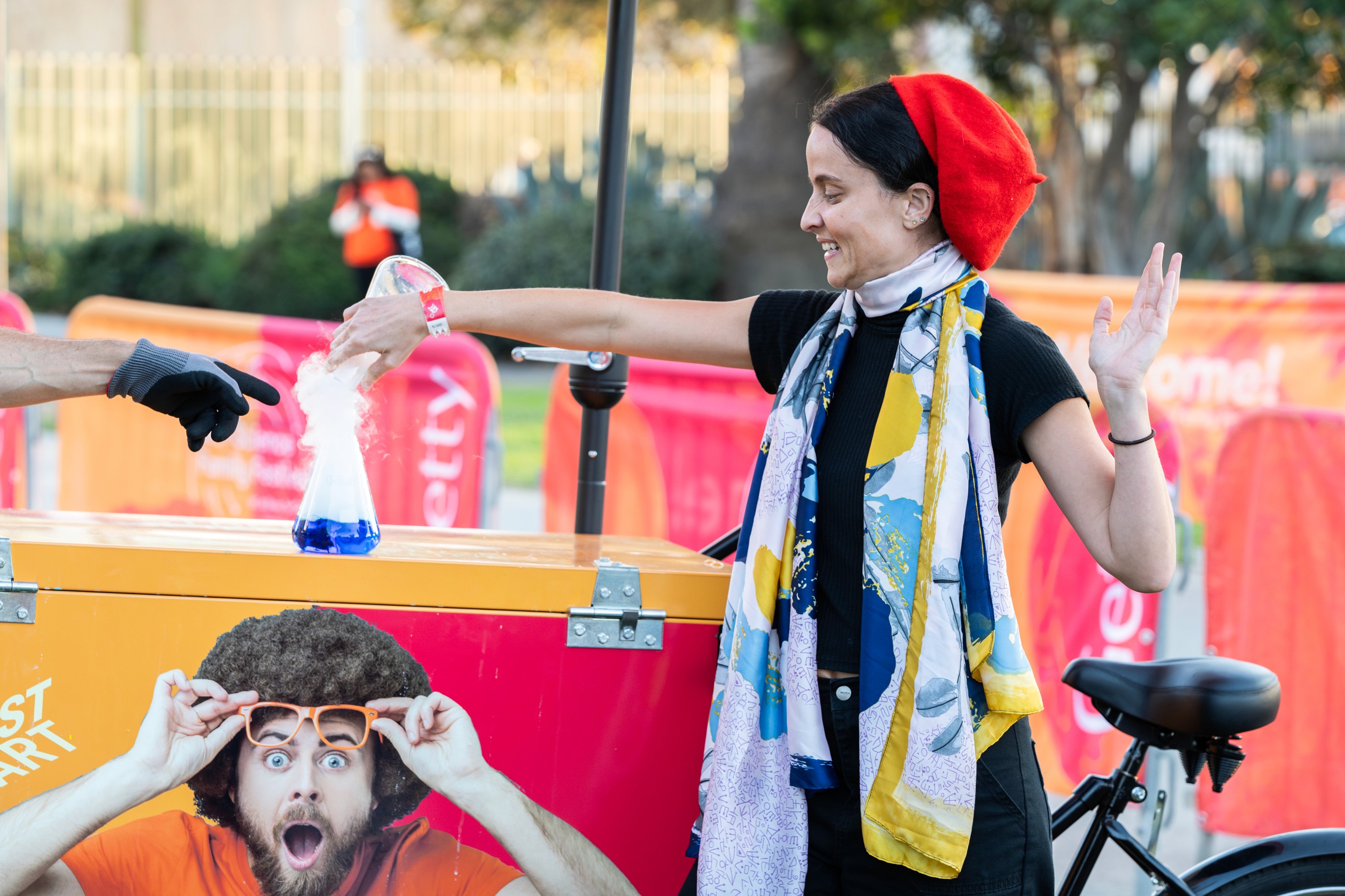 A young girl proudly showing her artwork at the family-friendly community event.