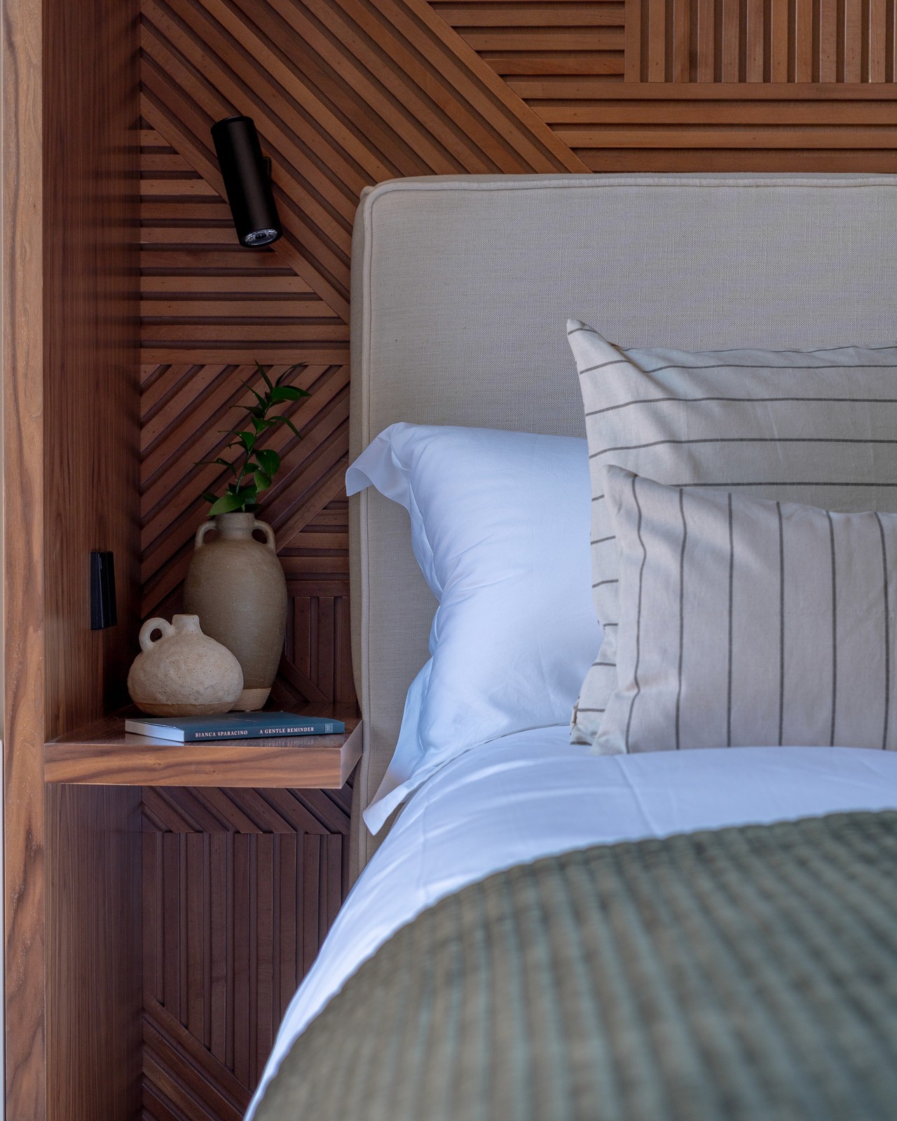 A clean, inviting bedroom with wooden backing