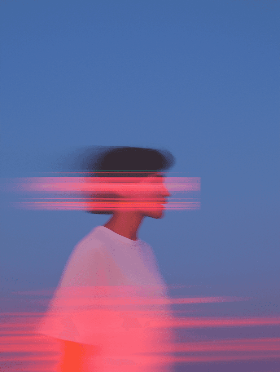 Side profile of DJ with red light trails across the face.