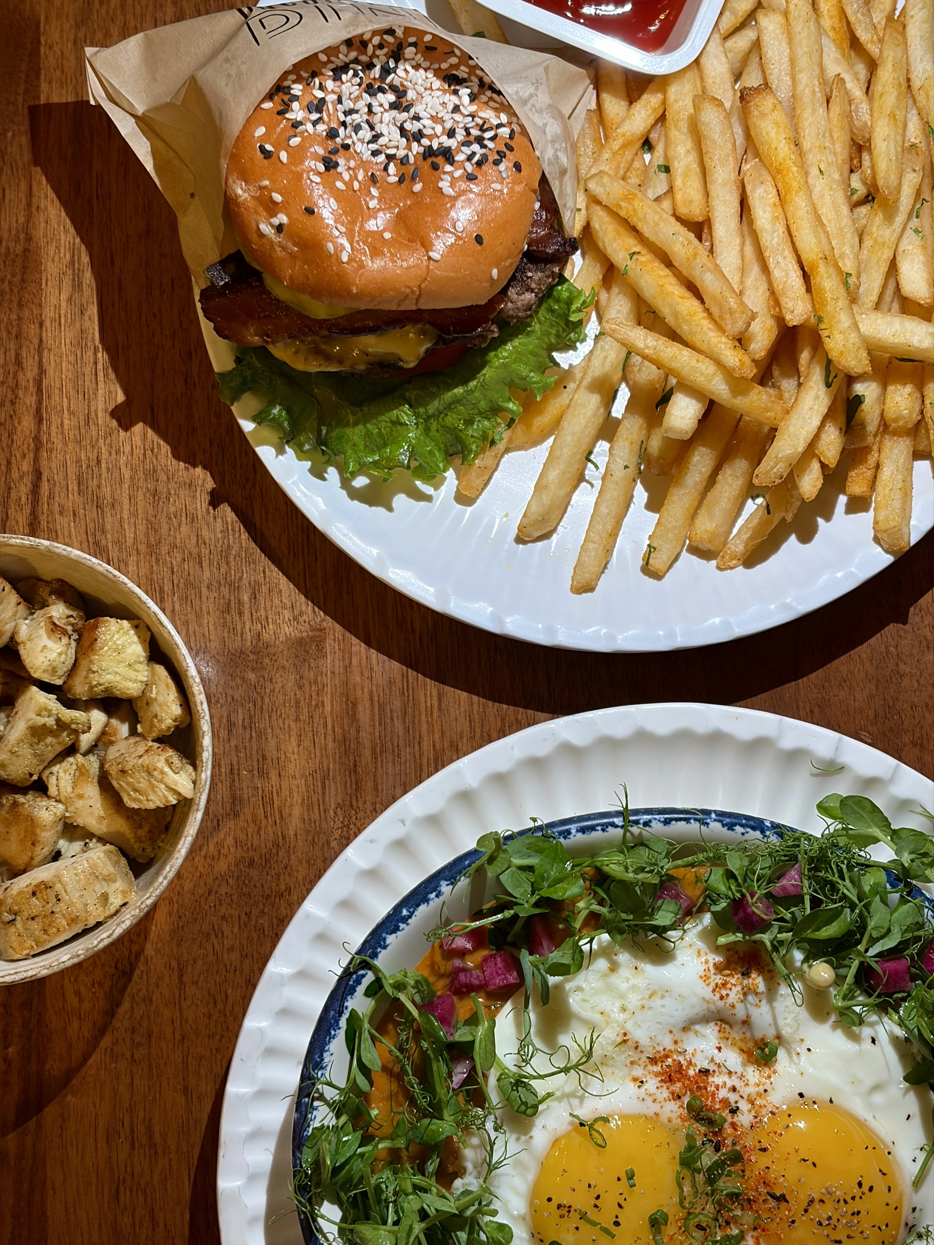 Unconventional diner dinner plates with a double cheeseburger and the sweet potato shakshuka with a side of chicken 