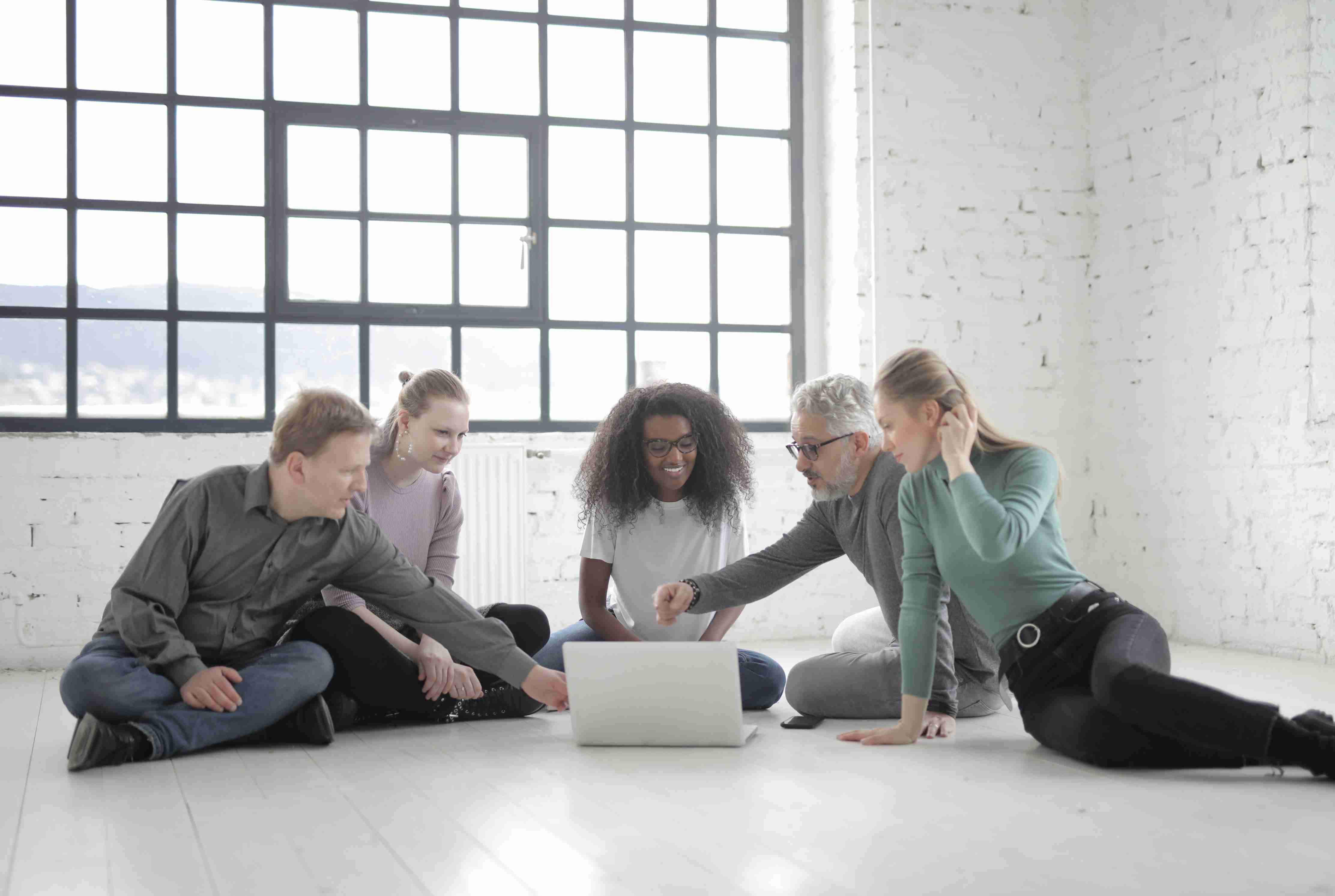 organization team members sitting on the floor and using enterprise web apps 