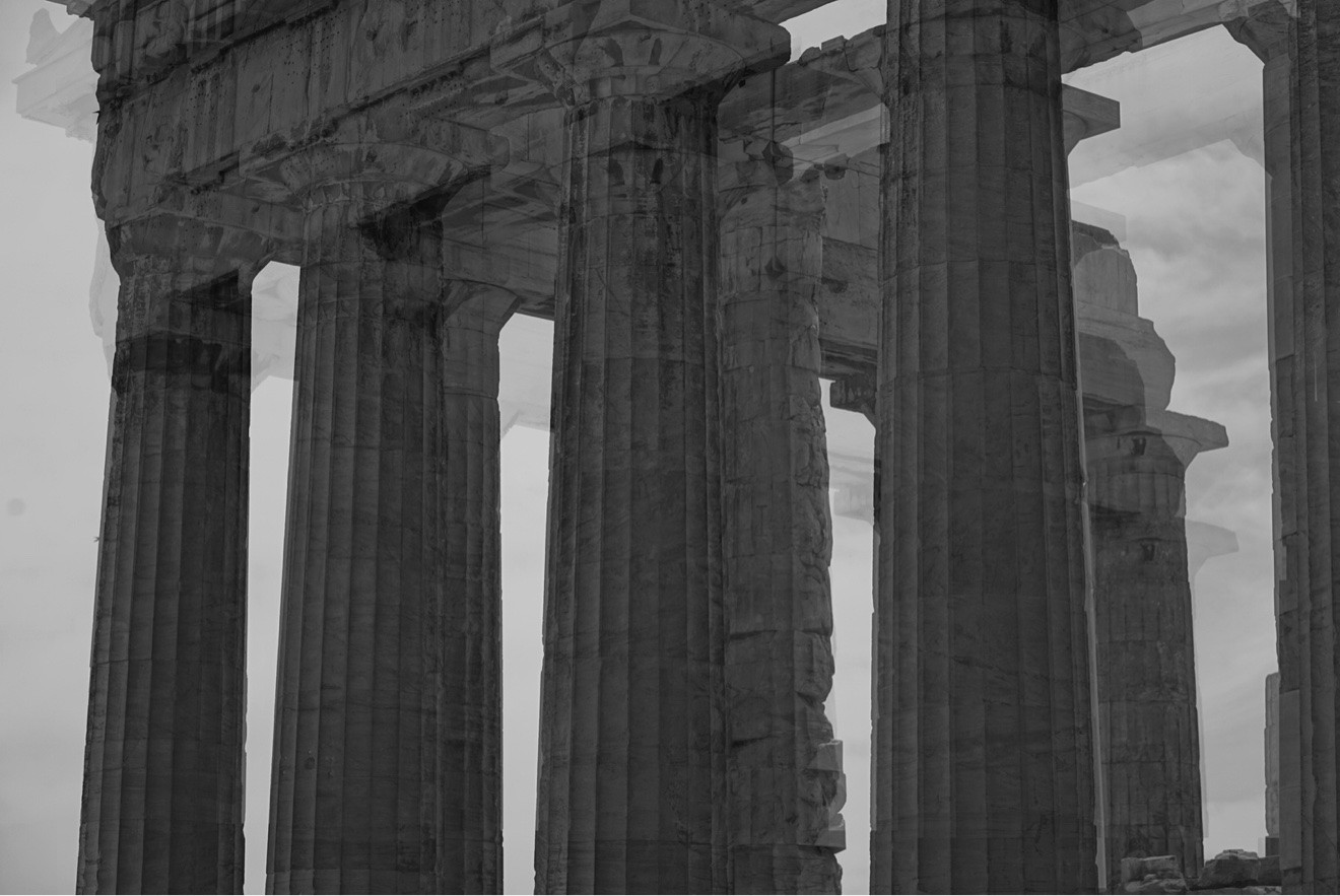 Black and white close-up of the Parthenon's towering Doric columns against the sky in Athens, Greece