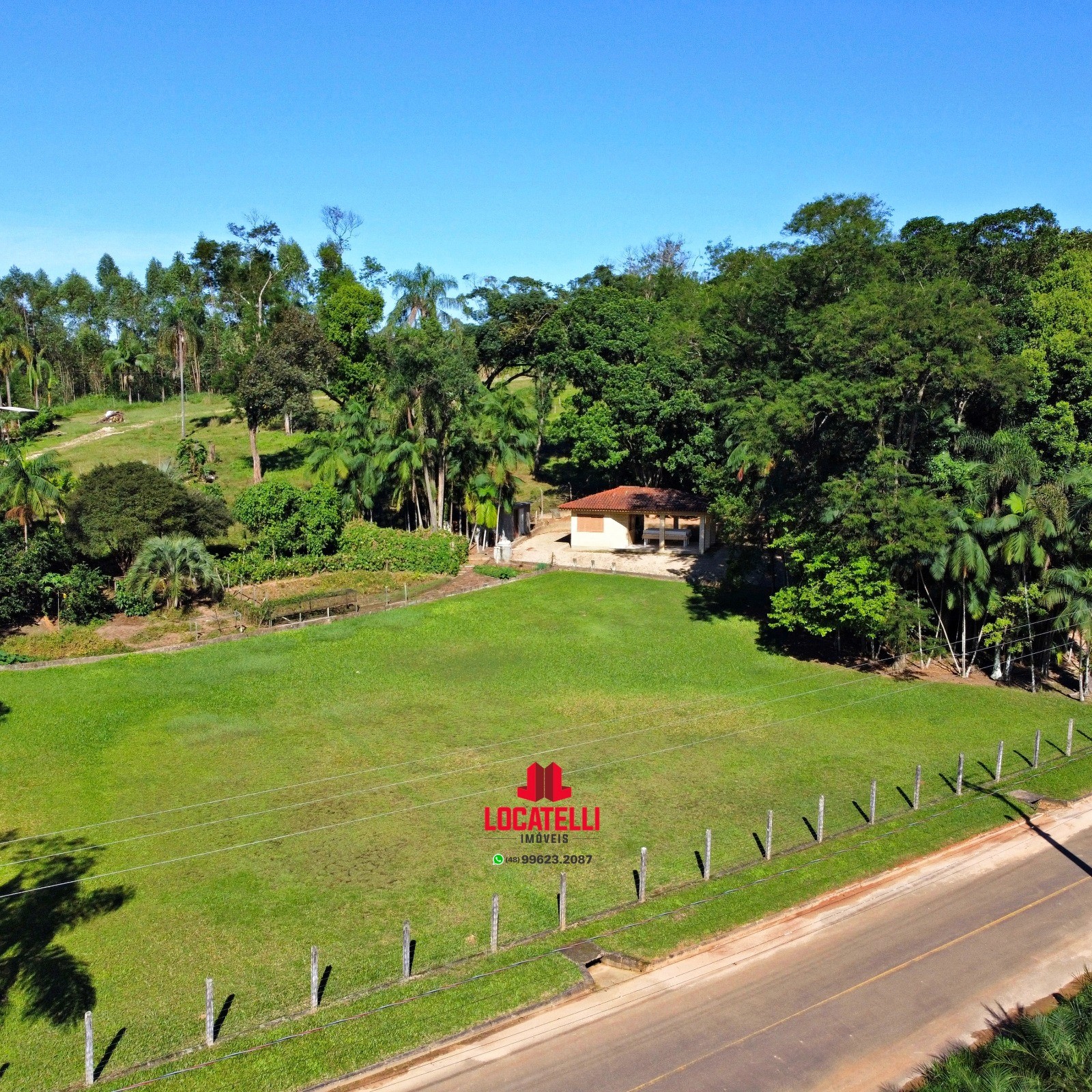A modern brick house with a two-car garage, well-manicured lawn, and clear blue sky in the background.