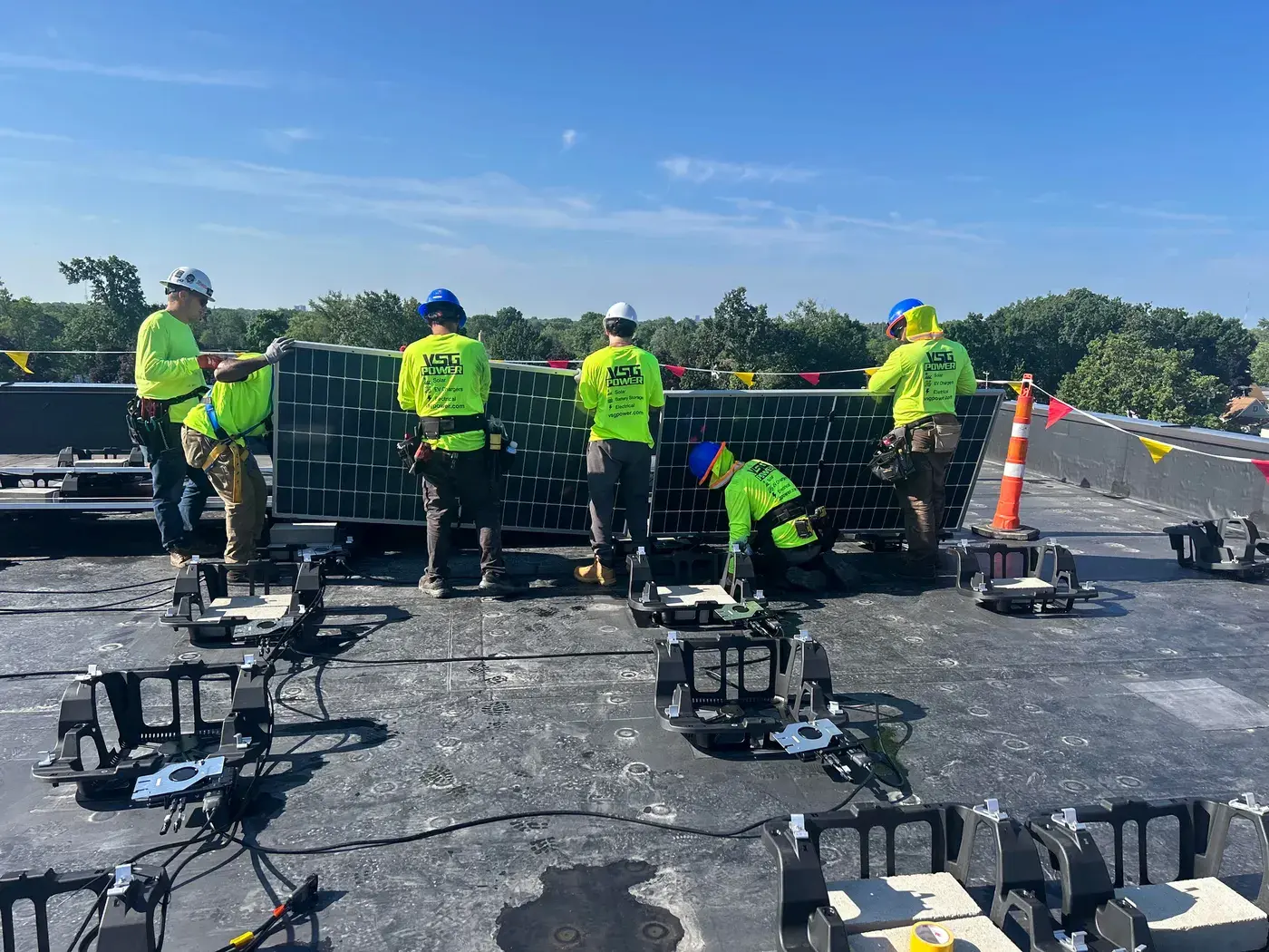 VSG Power crew installing solar panels on a flat commercial rooftop.