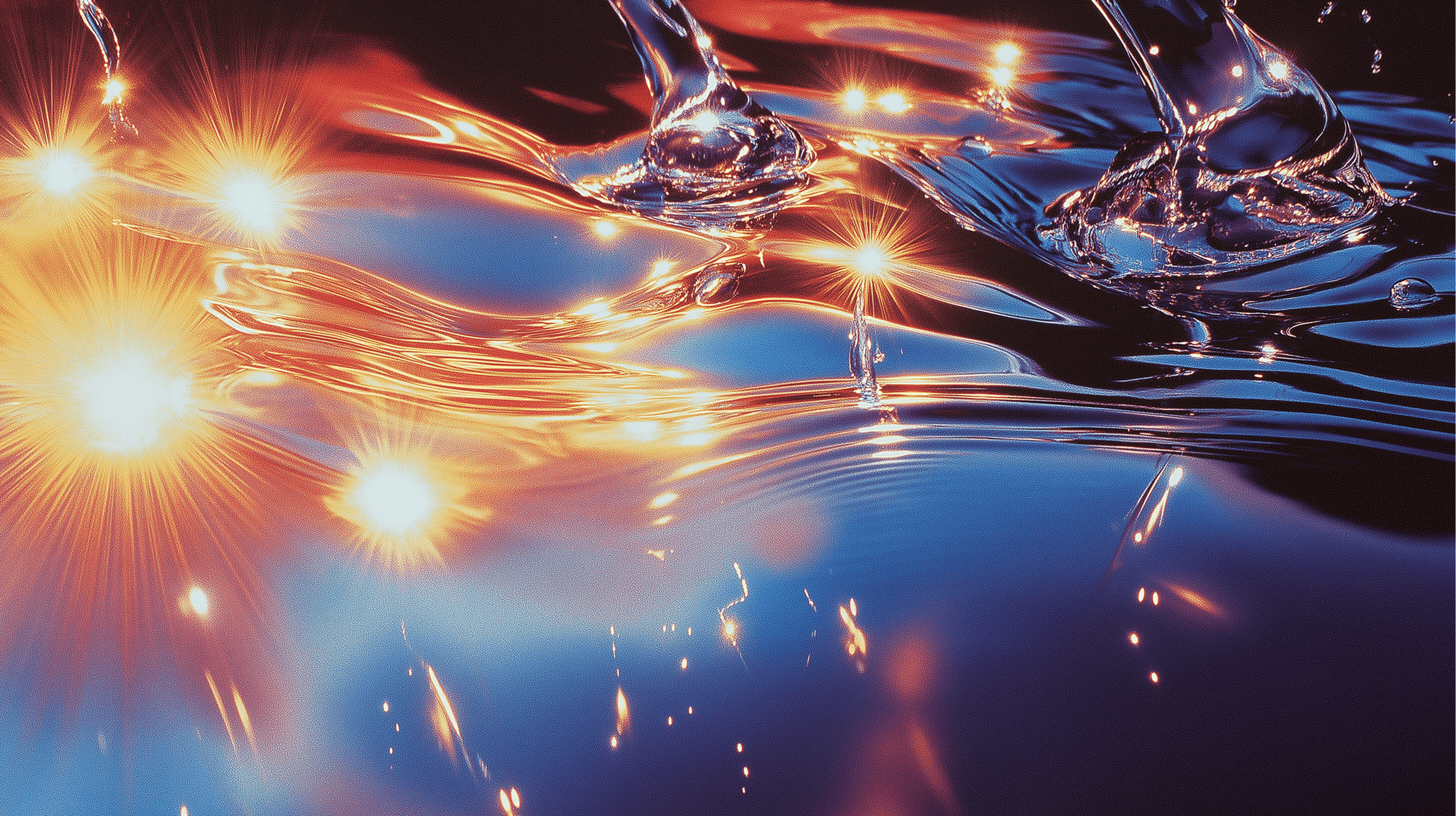 man wearing grey t-shirt standing in front of man sitting on chair
