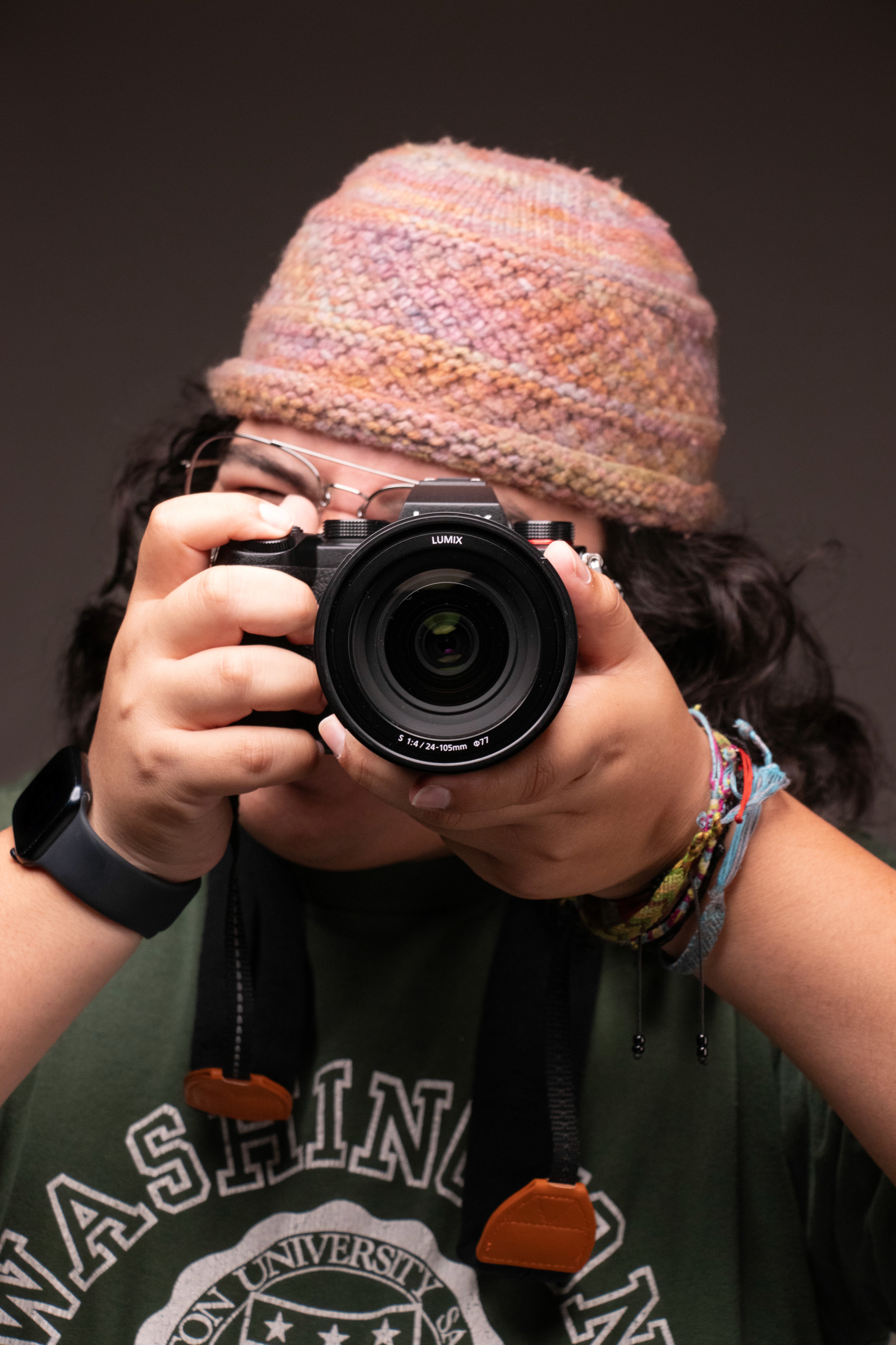 Photographer Frankie holding camera lens up to eye in Pasadena.
