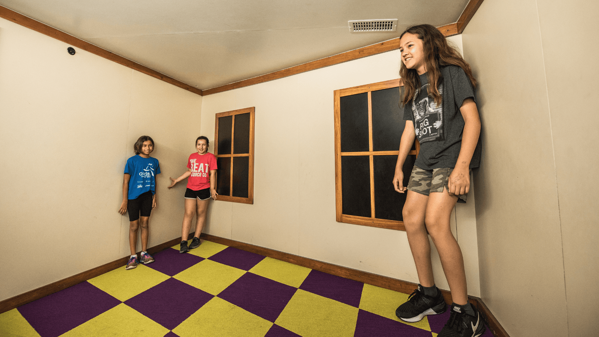 Three girls experience growing and shrinking through optical illusions.