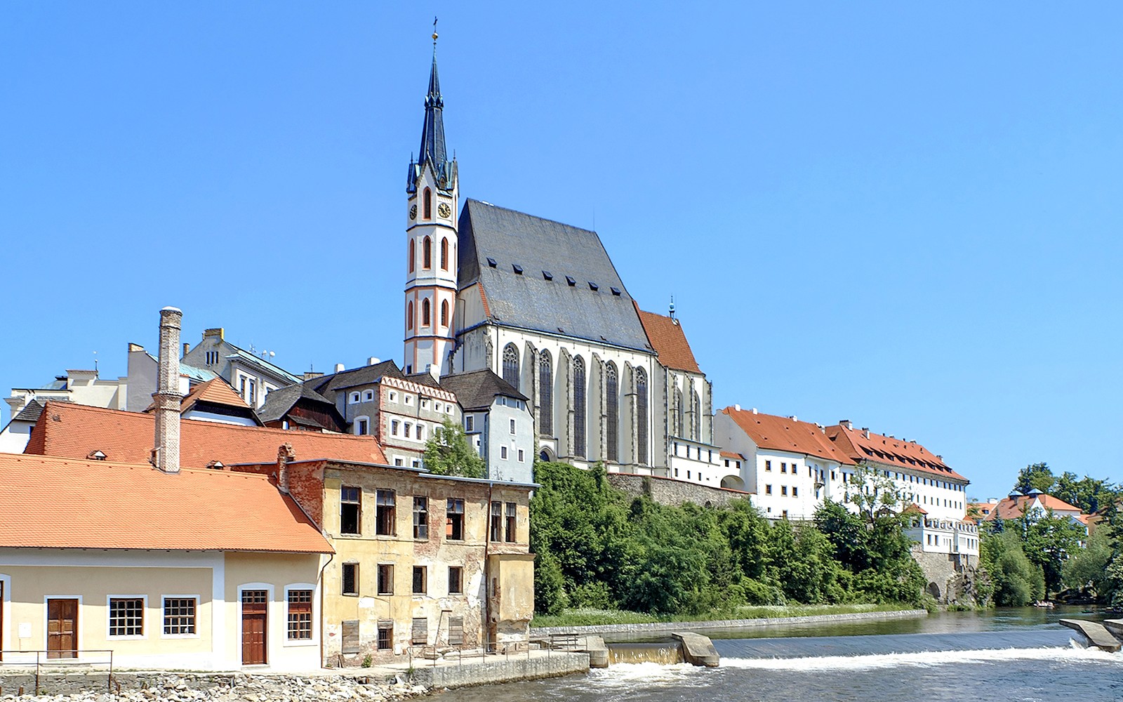 捷克克鲁姆洛夫的圣维特大教堂，以鲜明的哥特式建筑风格闻名，河畔两侧分布着历史悠久的建筑。