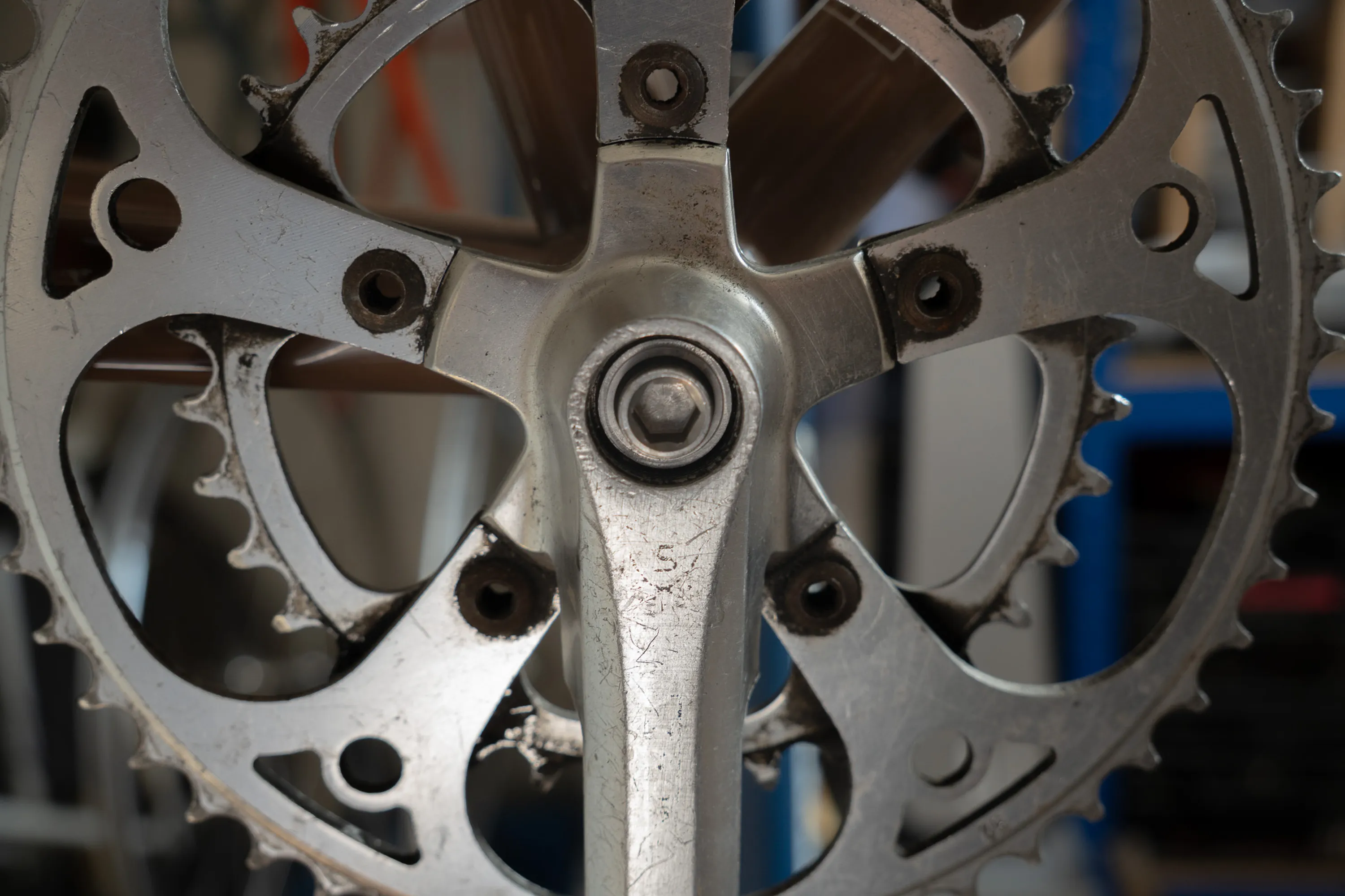 A close up of a person working on a bike crankset