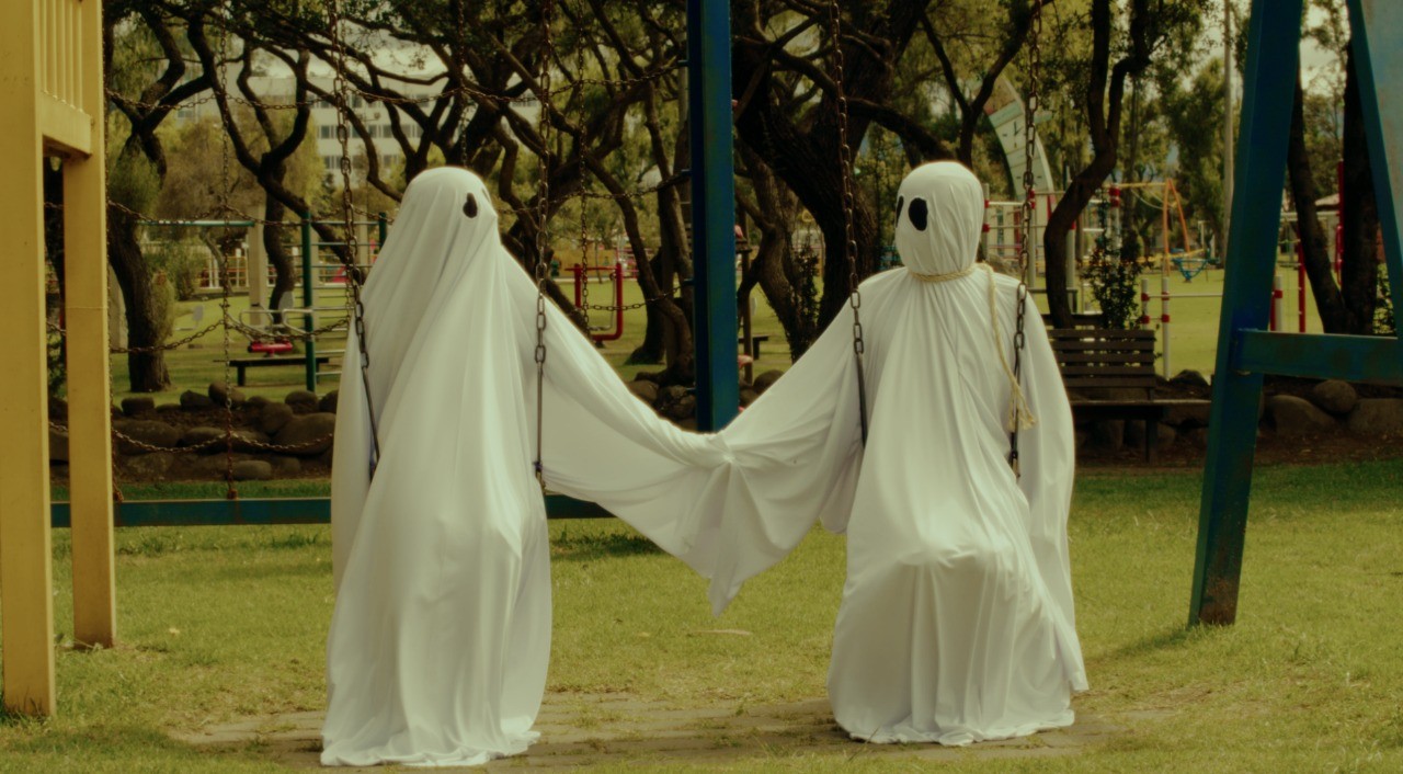 View of the French countryside through a stone villa’s open living room, with sofas and trees framing the scene