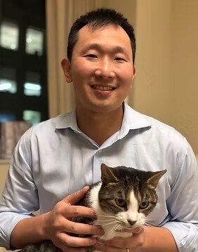 Matt holding his cat white colored cat with brown and black marks named Toni