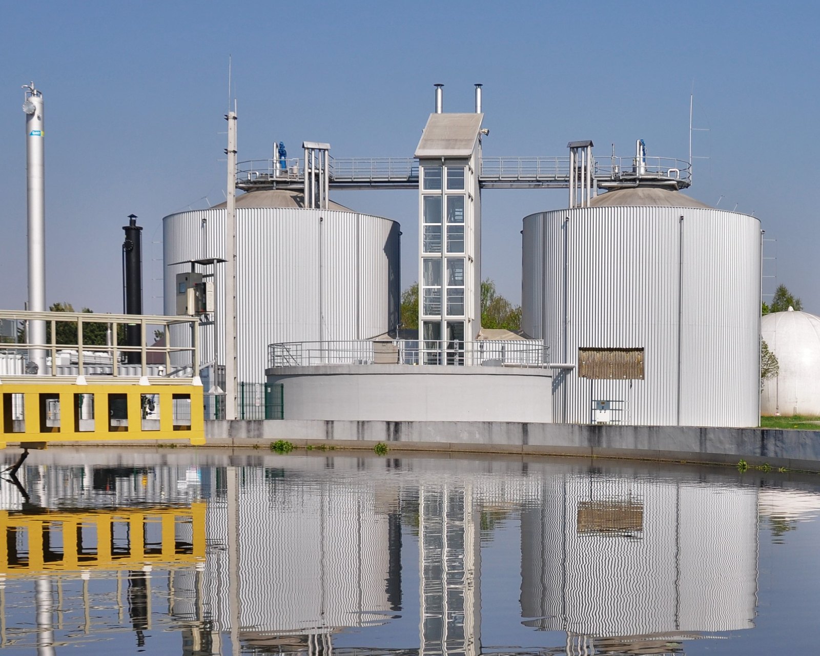 METHANATOR anaerobic digesters reflected in a clarifier at the Zalaegerszeg wastewater treatment plant, Hungary