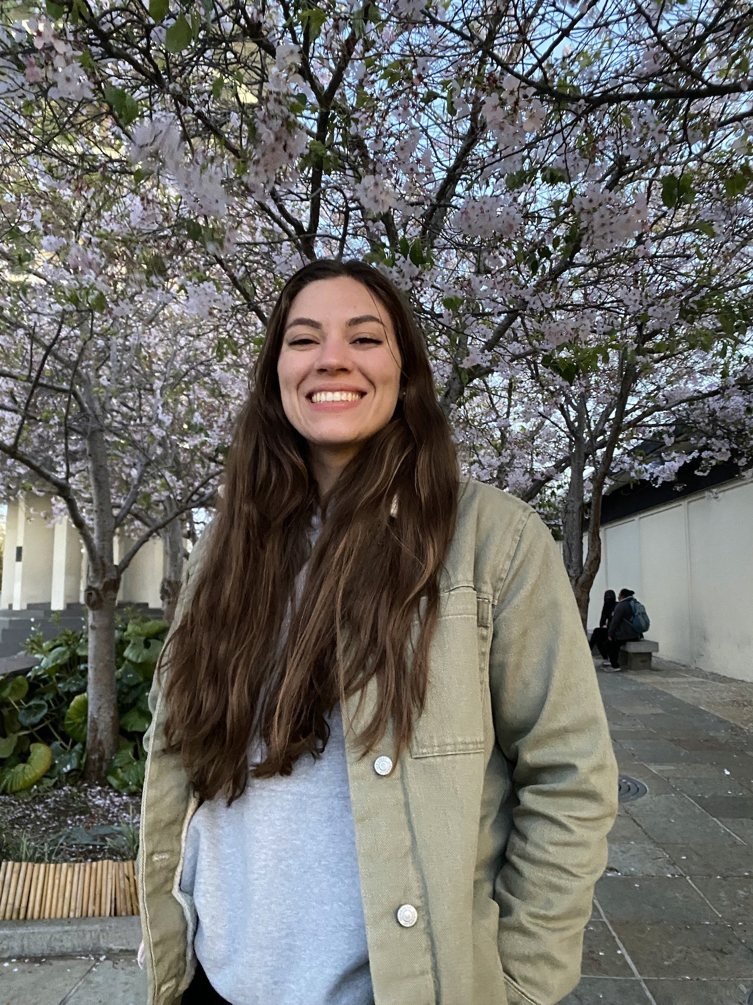 Samantha smiling in front of cherry blossoms
