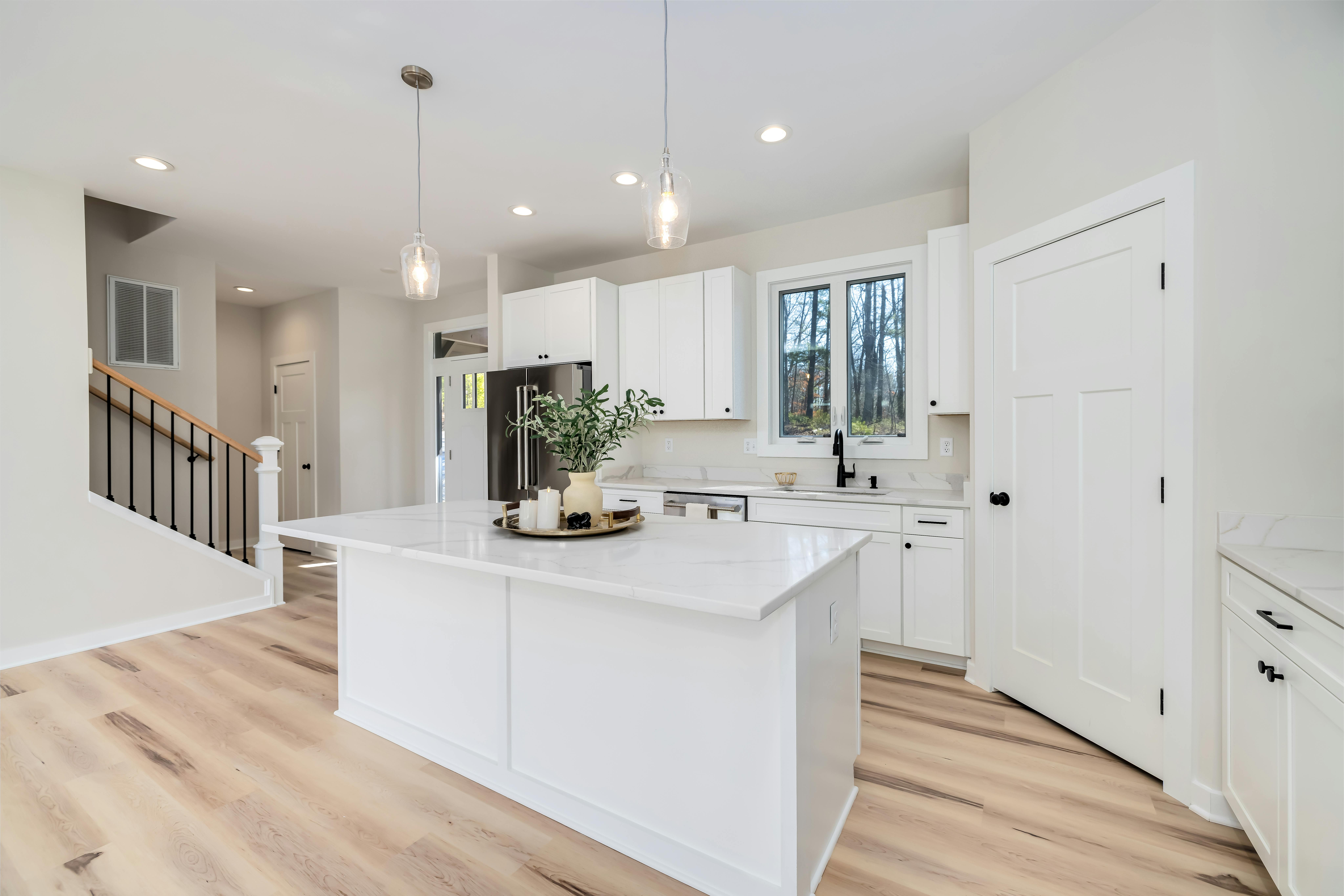Bright kitchen with white cabinetry, island bench and timber floors