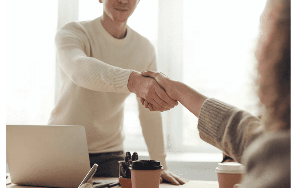 Two people shaking hands, symbolizing trust and professionalism, representing the ethical considerations in AI-driven interviews, including fairness, transparency, and the need for human oversight.