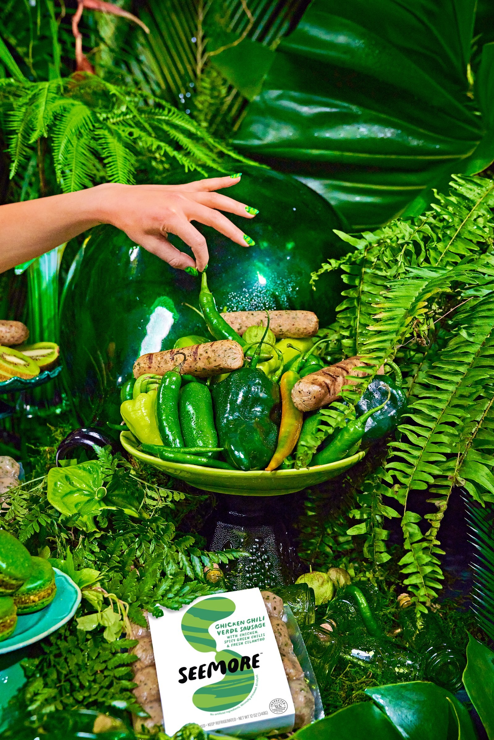 A hand reaching toward the Salsa Verde sausage arrangement