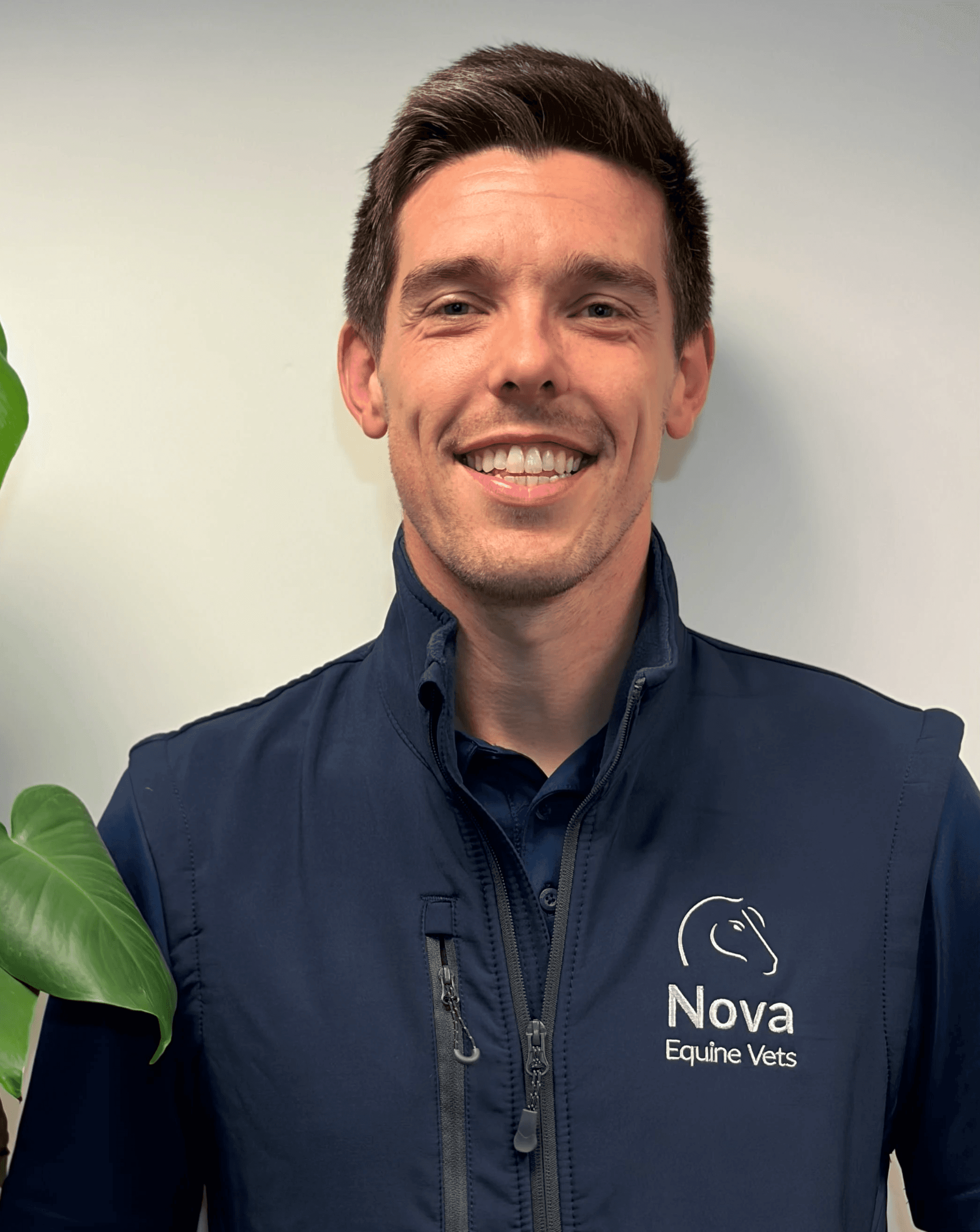 a man in a blue shirt smiling at the camera