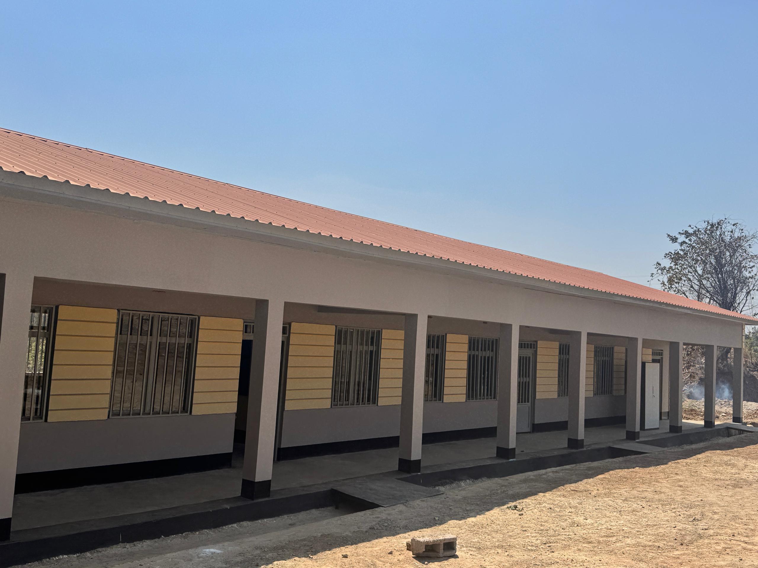 Aerial view of a winding road cutting through rocky terrain and sandy landscape.