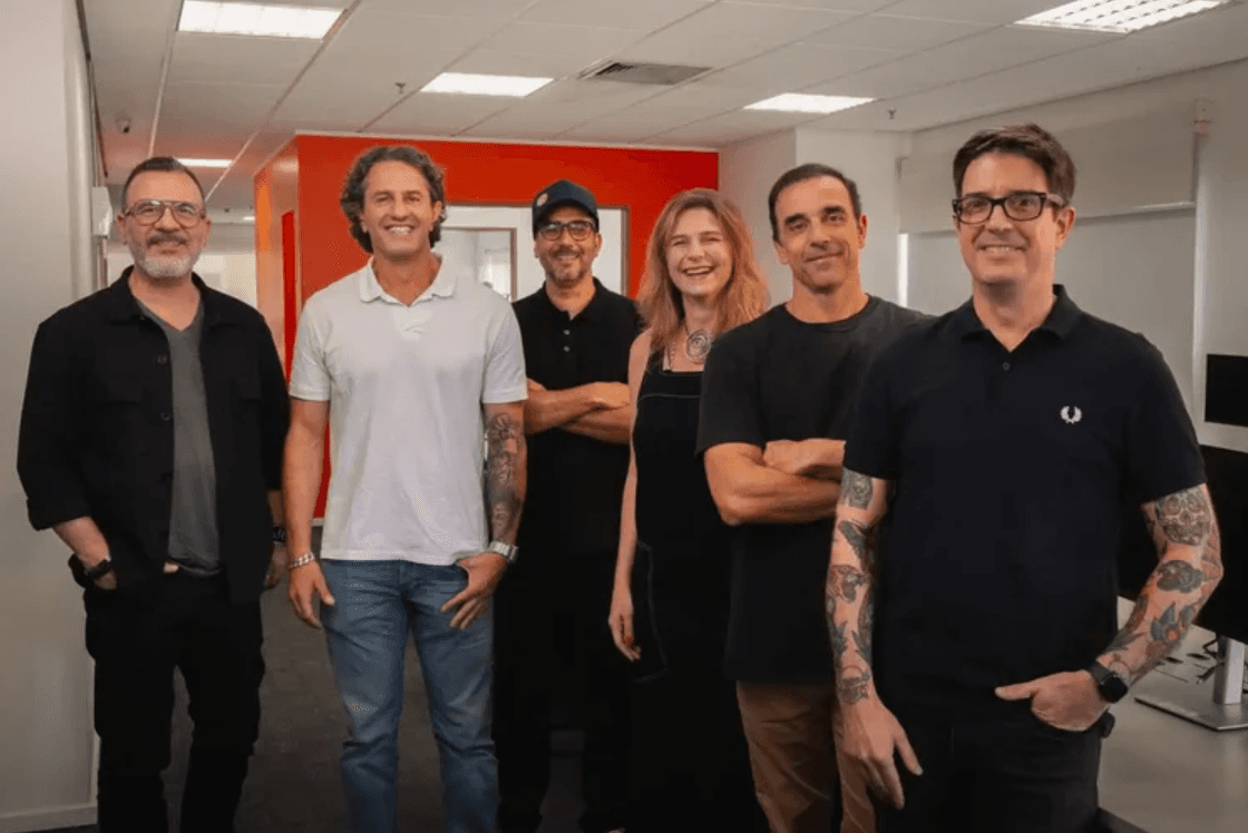 Seis pessoas em pé  dentro de um escritório