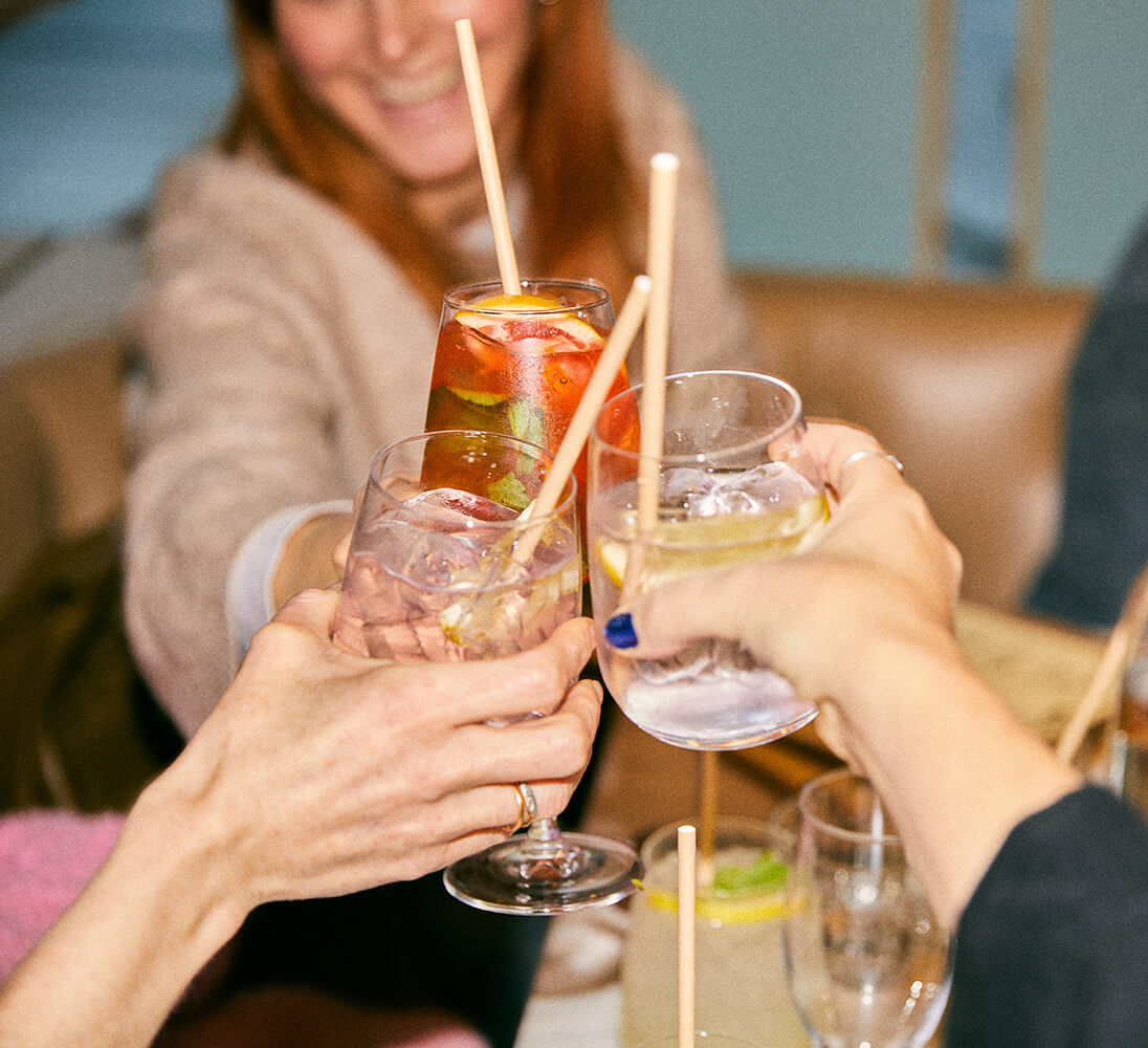 Three people doing a cheers with drinks
