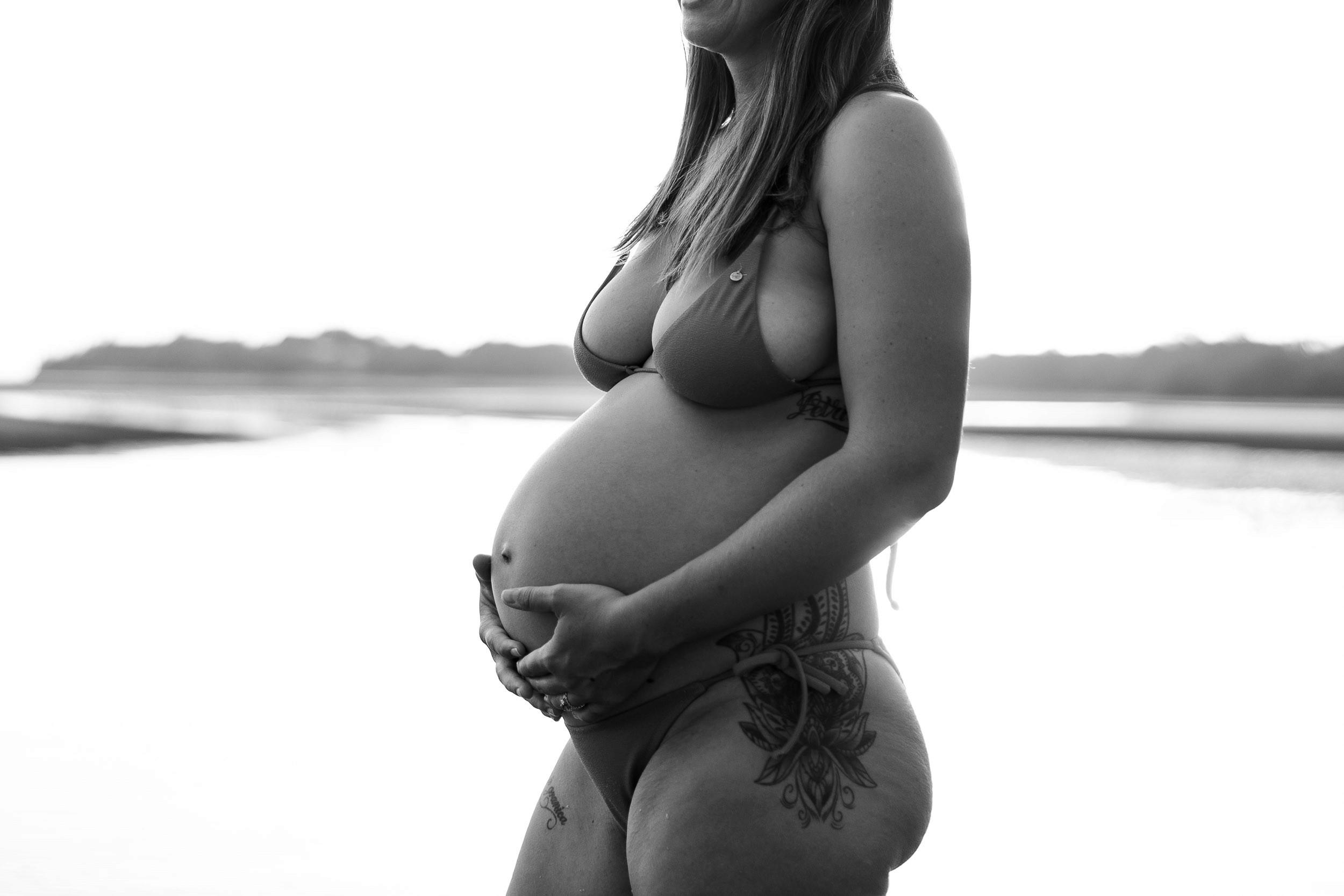 Close-up of hands resting on baby bump during maternity session in Mackay
