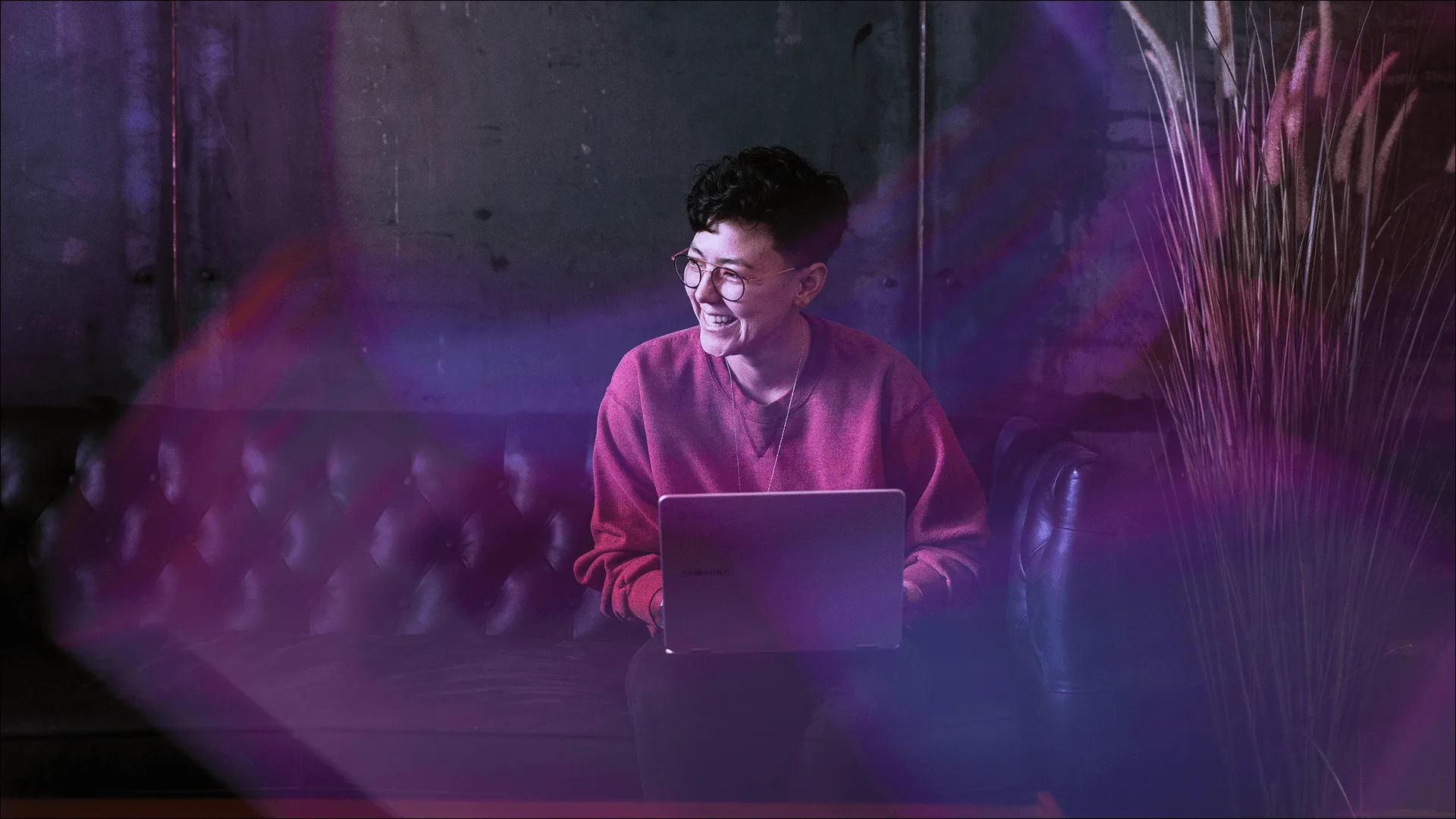 A woman sits behind her laptop, smiling, turning AI into experience advantage