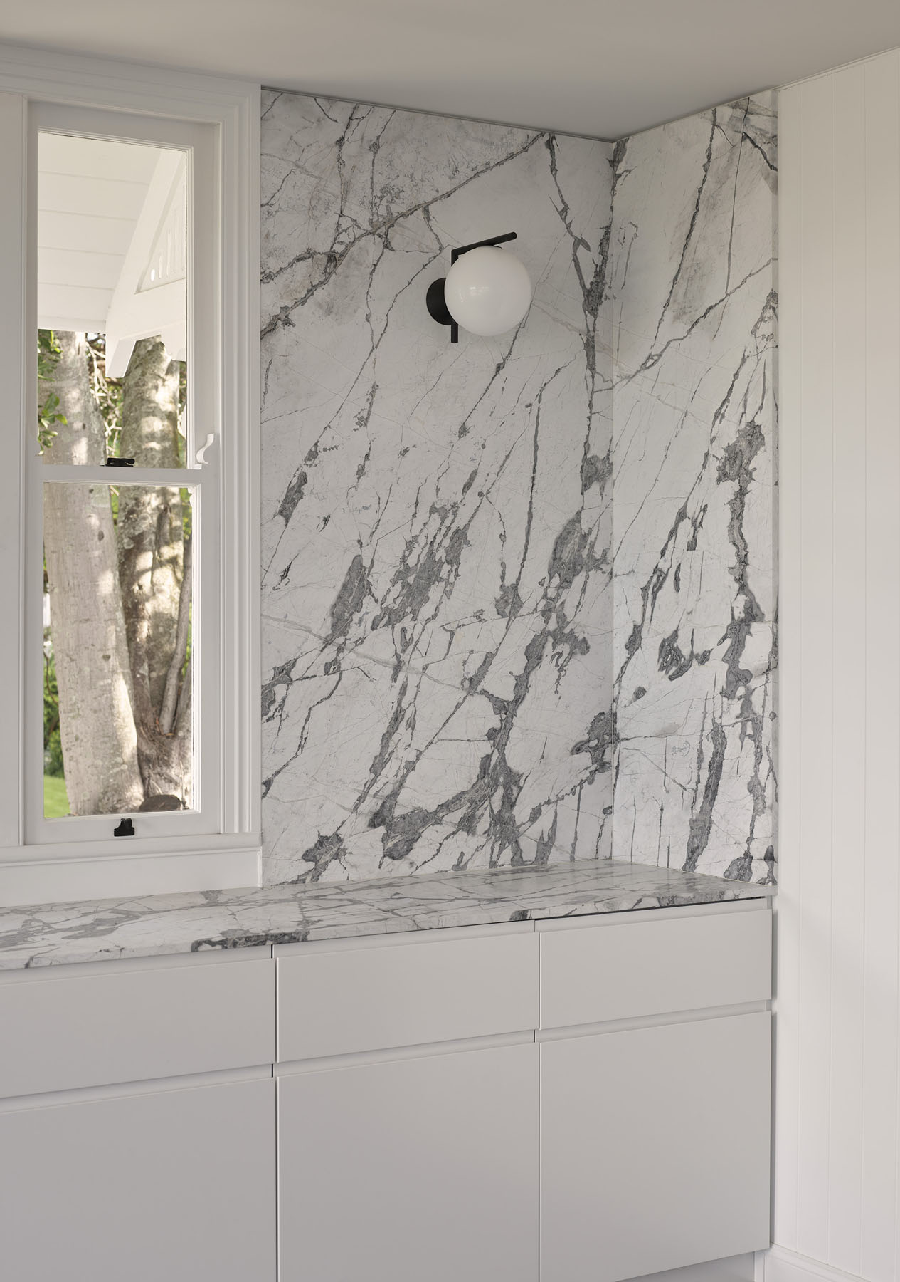 interior with marble splashback, built-in cabinetry and central window
