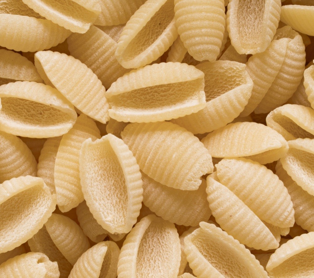 Dry gnocchetti sardi piled together, small ridged shells with hollow undersides.