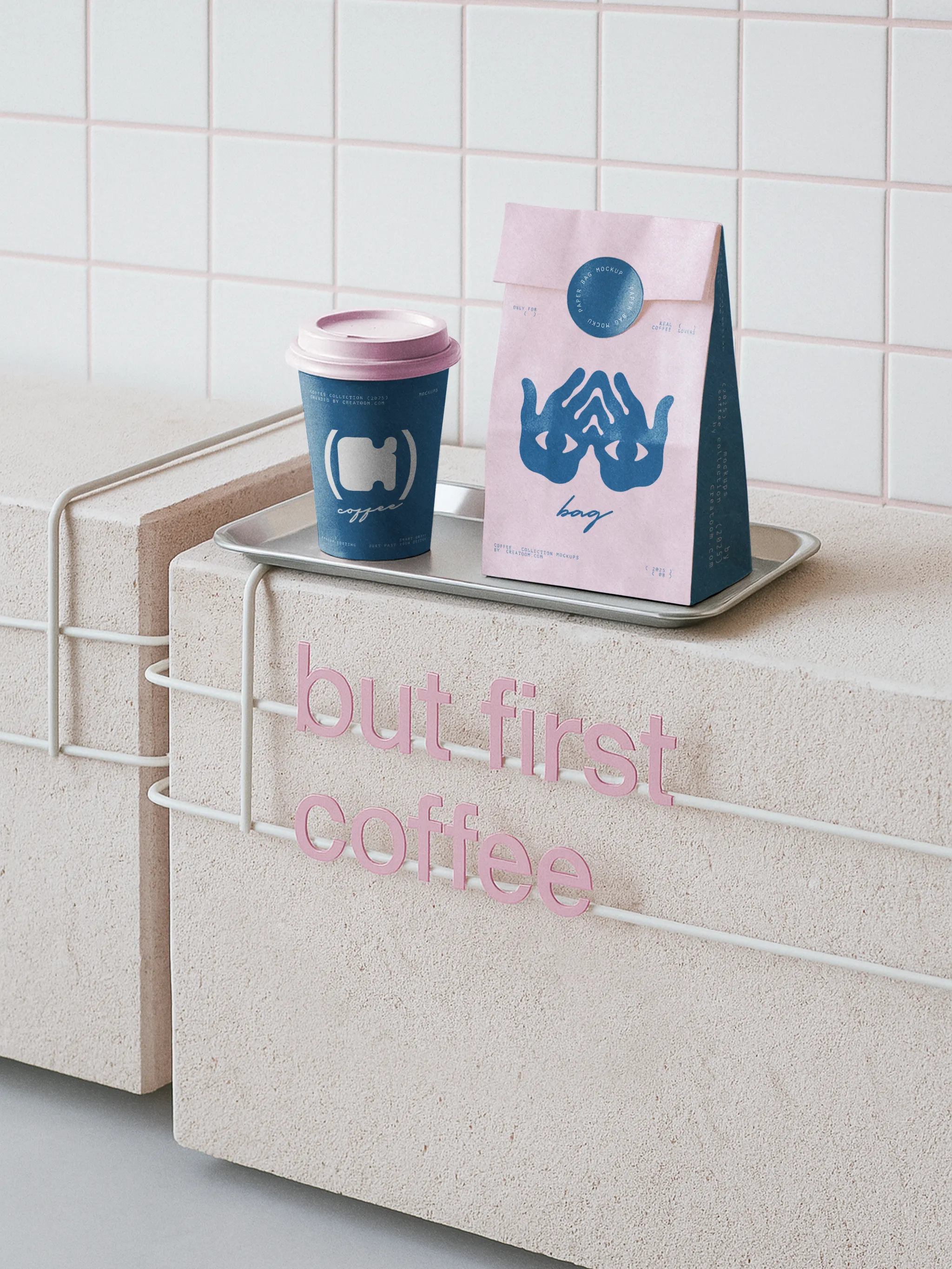 Branded paper bag and coffee cup on stone block with pink lettering that reads “but first coffee”