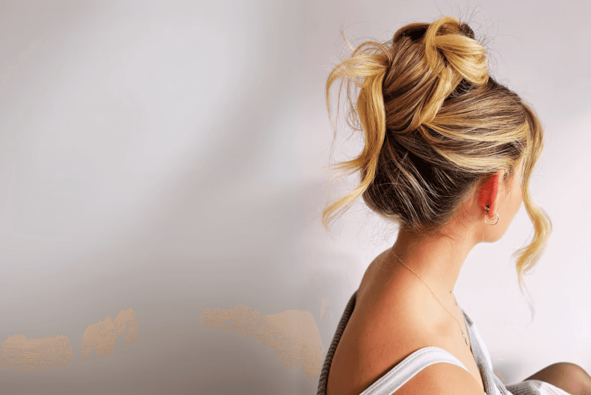 Woman with blonde hair tied up into a messy bun