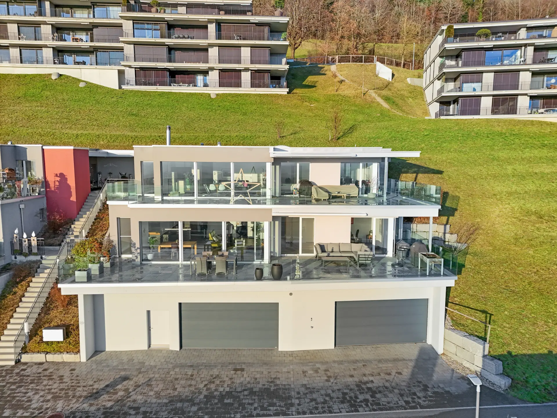 Drohnenaufnahme eines modernen Mehrfamilienhauses in erhöhter Hanglage