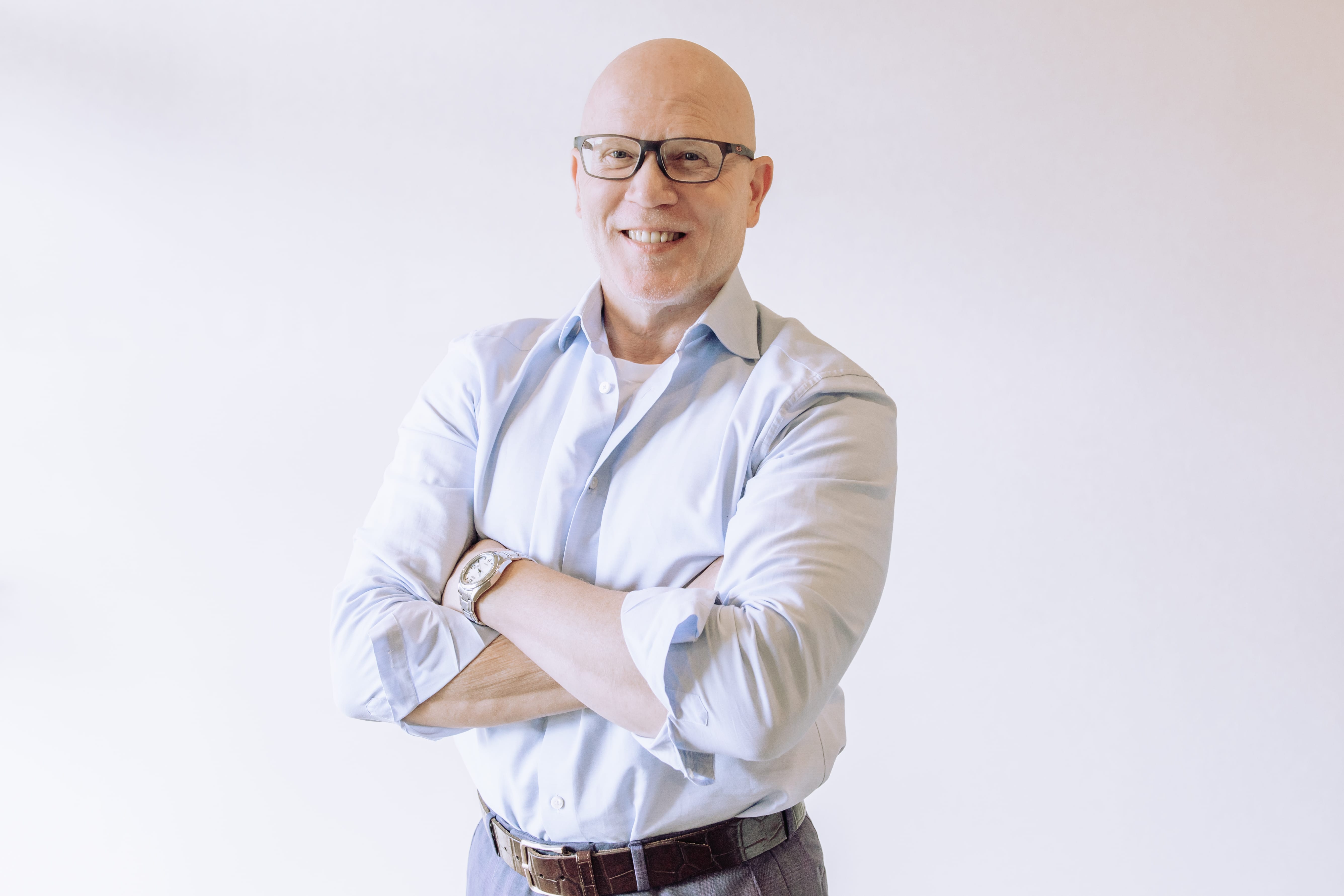 A headshot of a smiling male doctor.