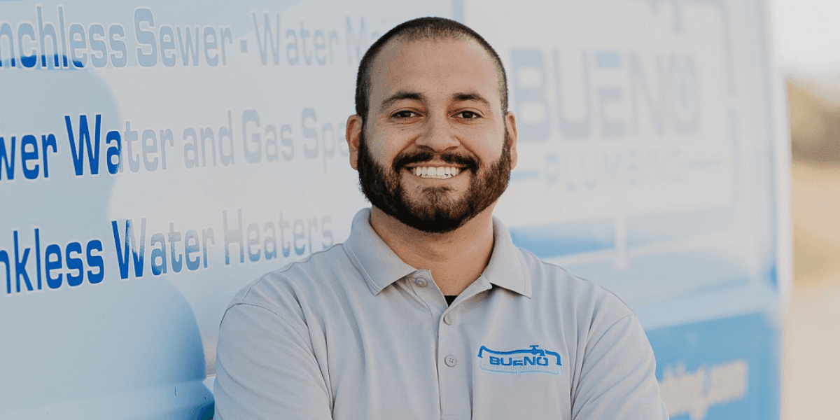 Kevin Bueno of Bueno Plumbing and Rooter standing in front of a company service vehicle.