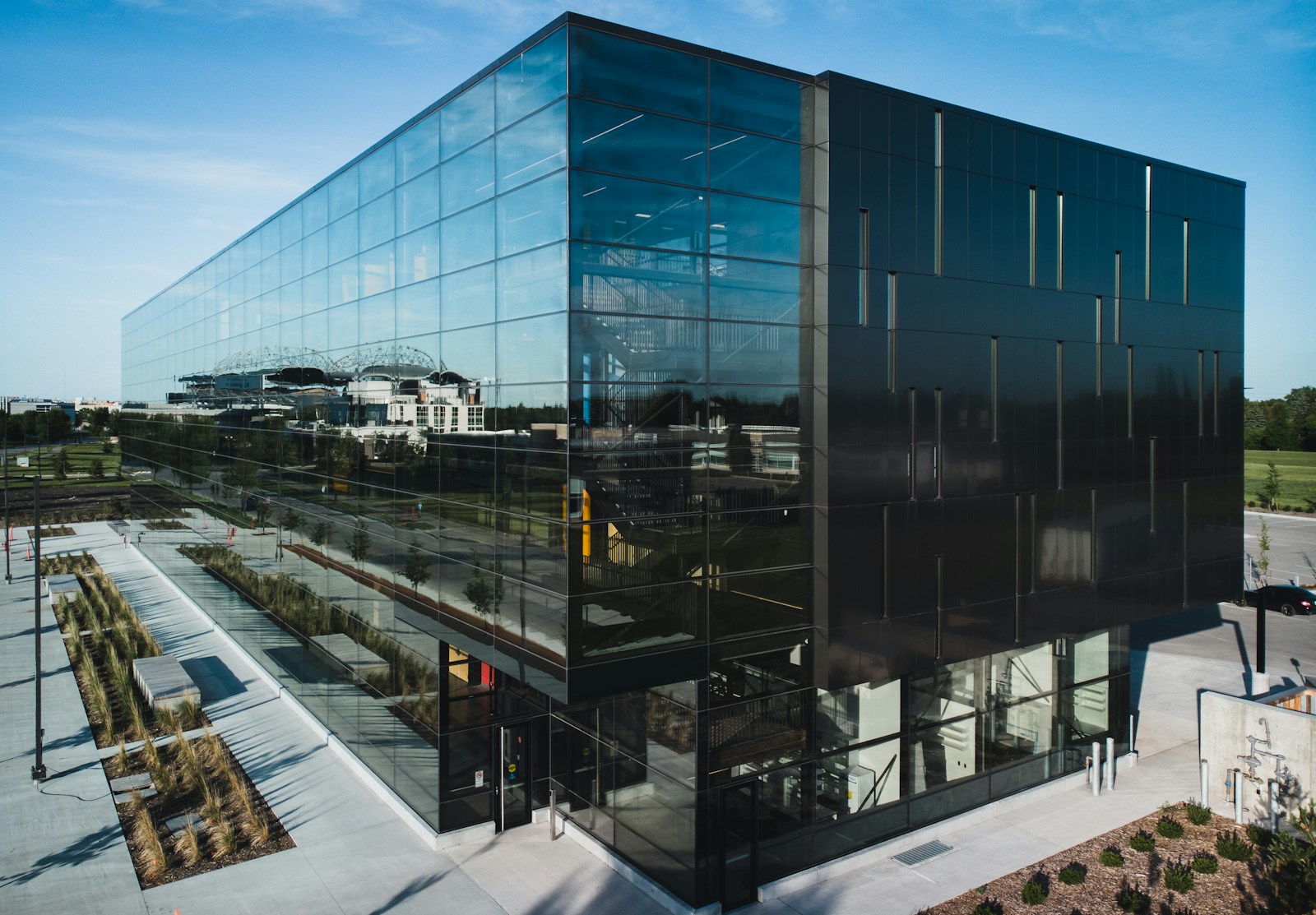 Glass-fronted office building beside a landscaped yard